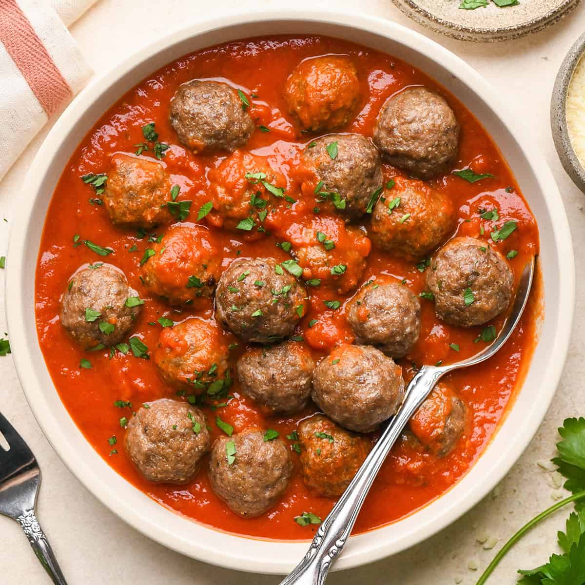 Gluten Free Meatballs in a bowl with marinara sauce and a spoon