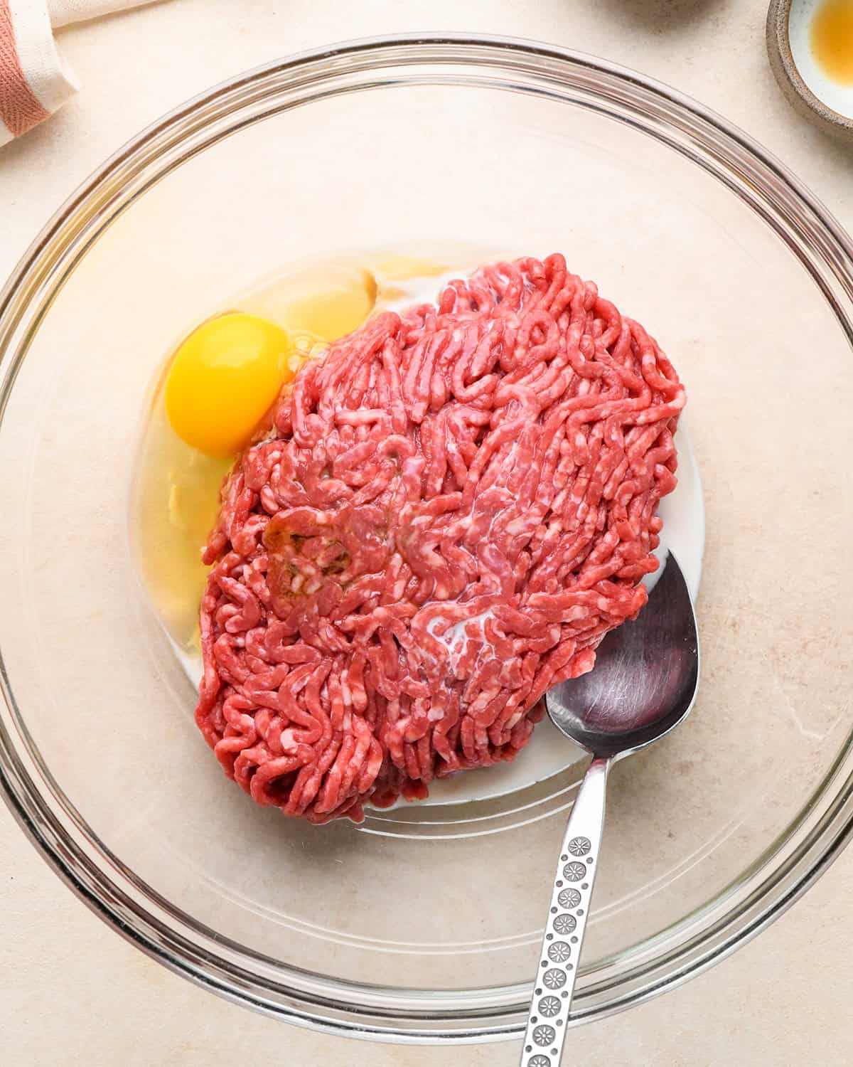 how to make Gluten Free Meatballs - ground beef, egg and milk in a bowl before mixing