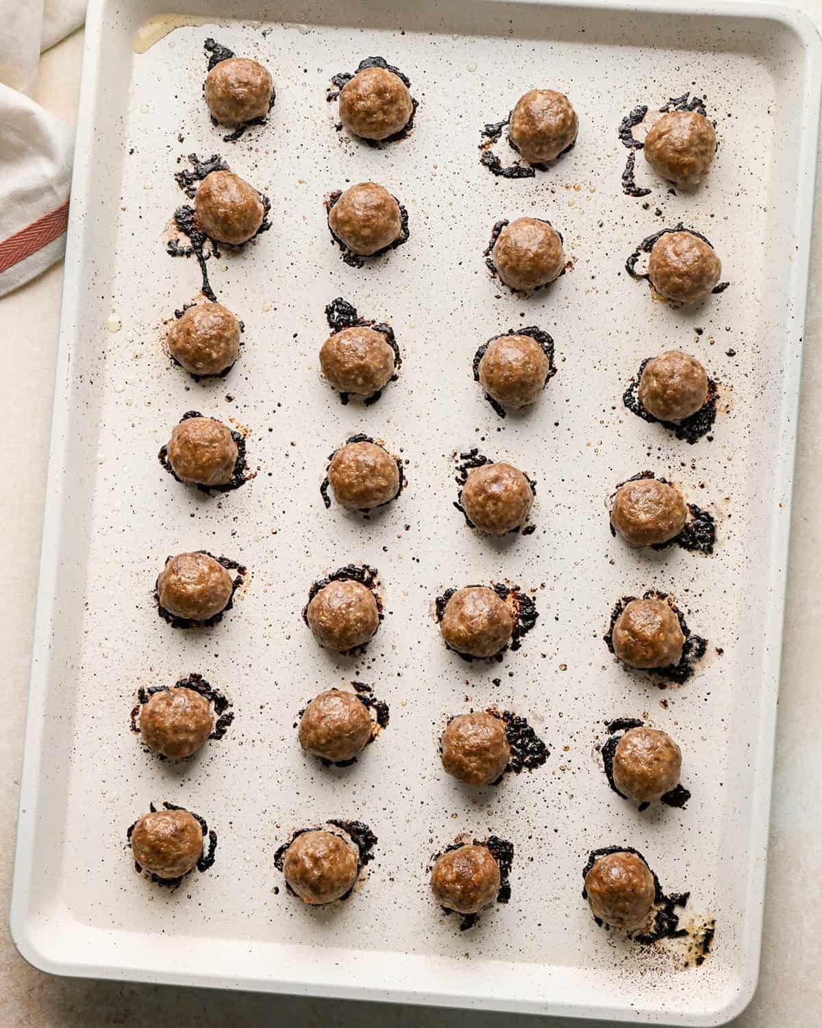 28 gluten free meatballs on a baking sheet after baking