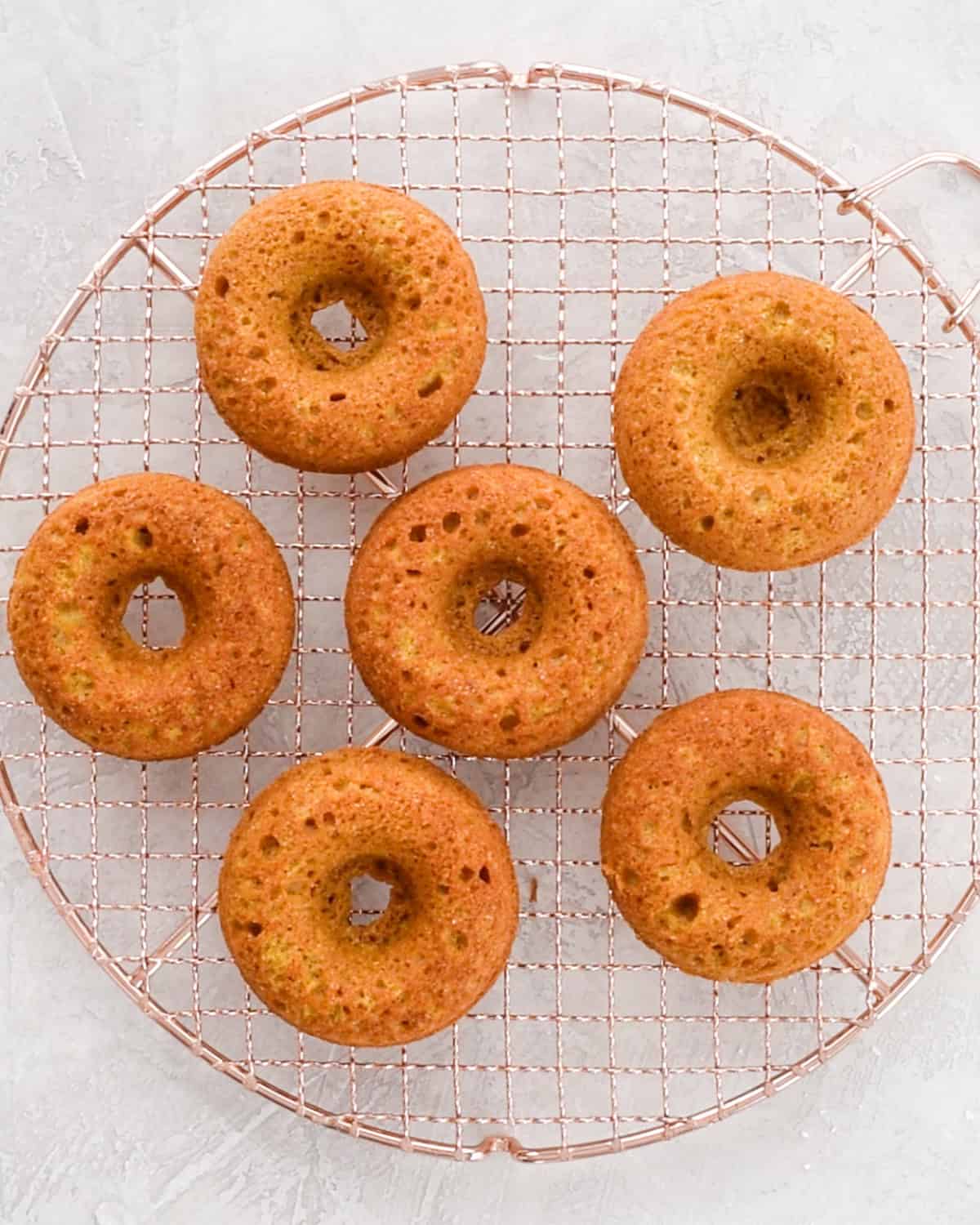Baked Pumpkin Donuts on a wire cooling rack
