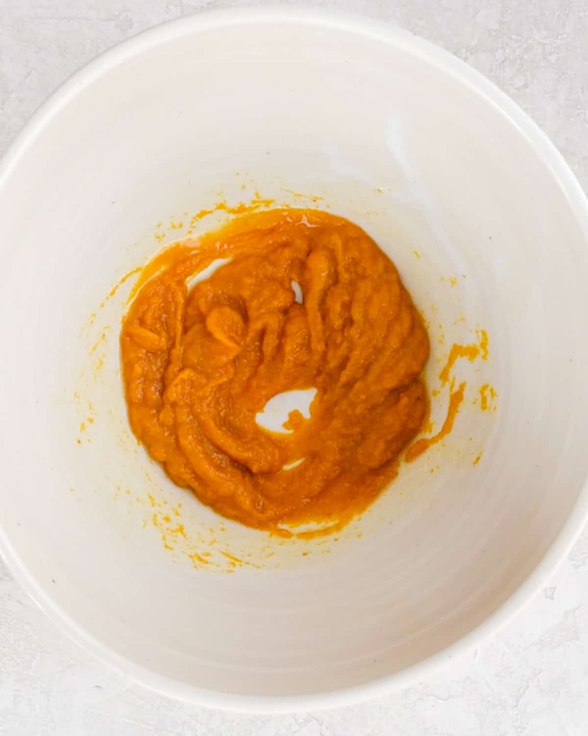 how to make Baked Pumpkin Donuts -  butter and pumpkin puree in a bowl after mixing