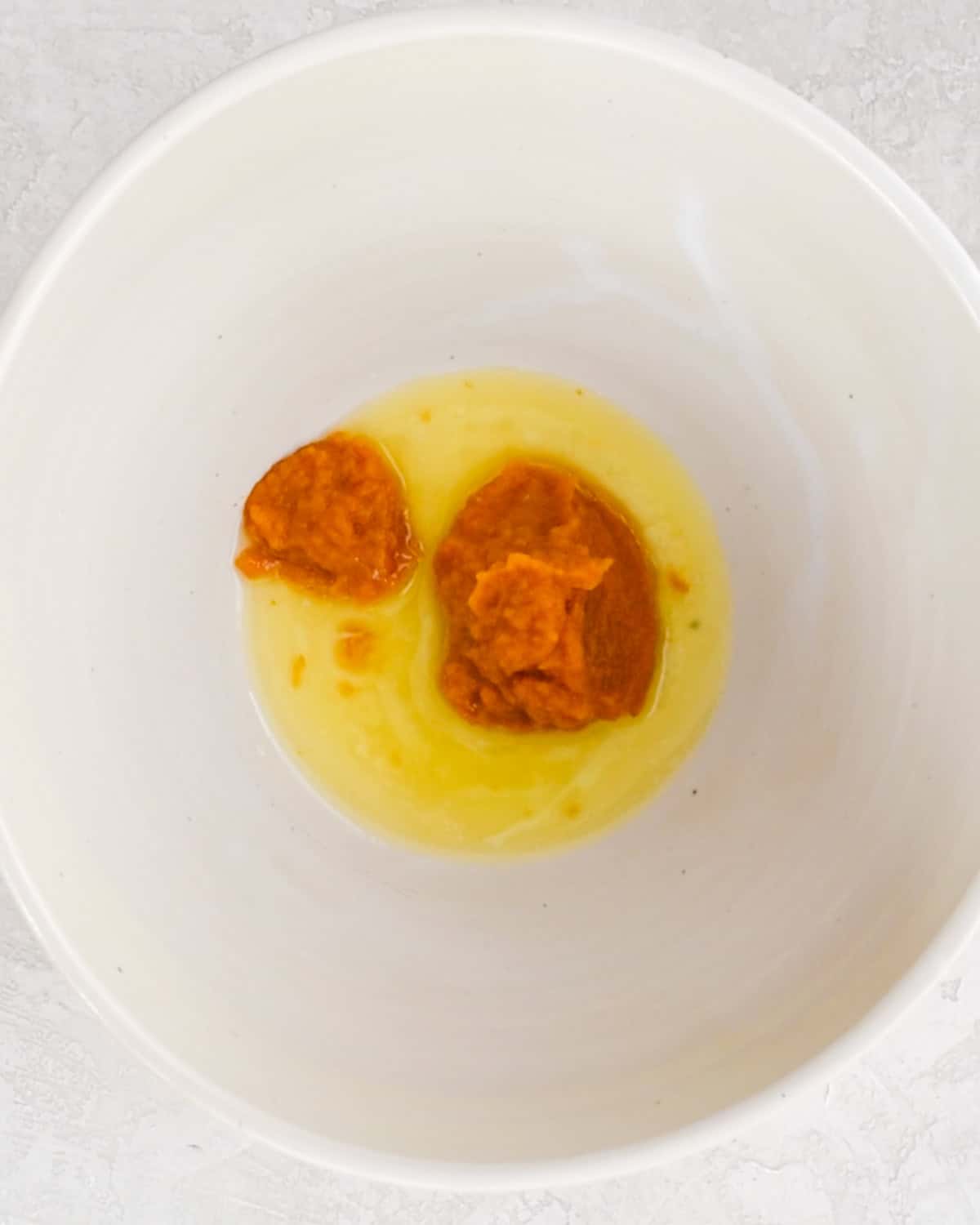 how to make Baked Pumpkin Donuts -  butter and pumpkin puree in a bowl before mixing