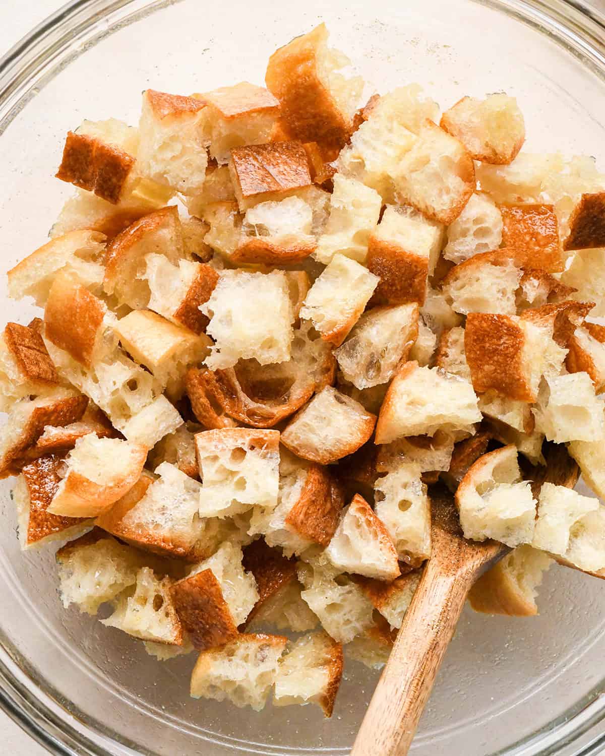 How to Make Croutons - stirring the croutons with a wooden spoon in a bowl