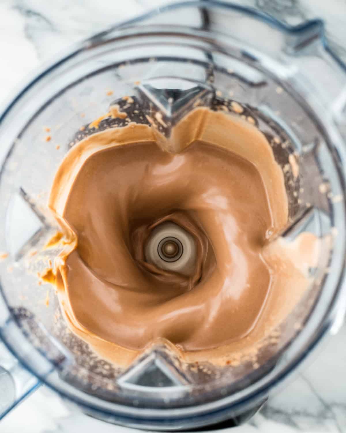 making Dairy Free Chocolate Peanut Butter Ice Cream in a blender container - ingredients blending
