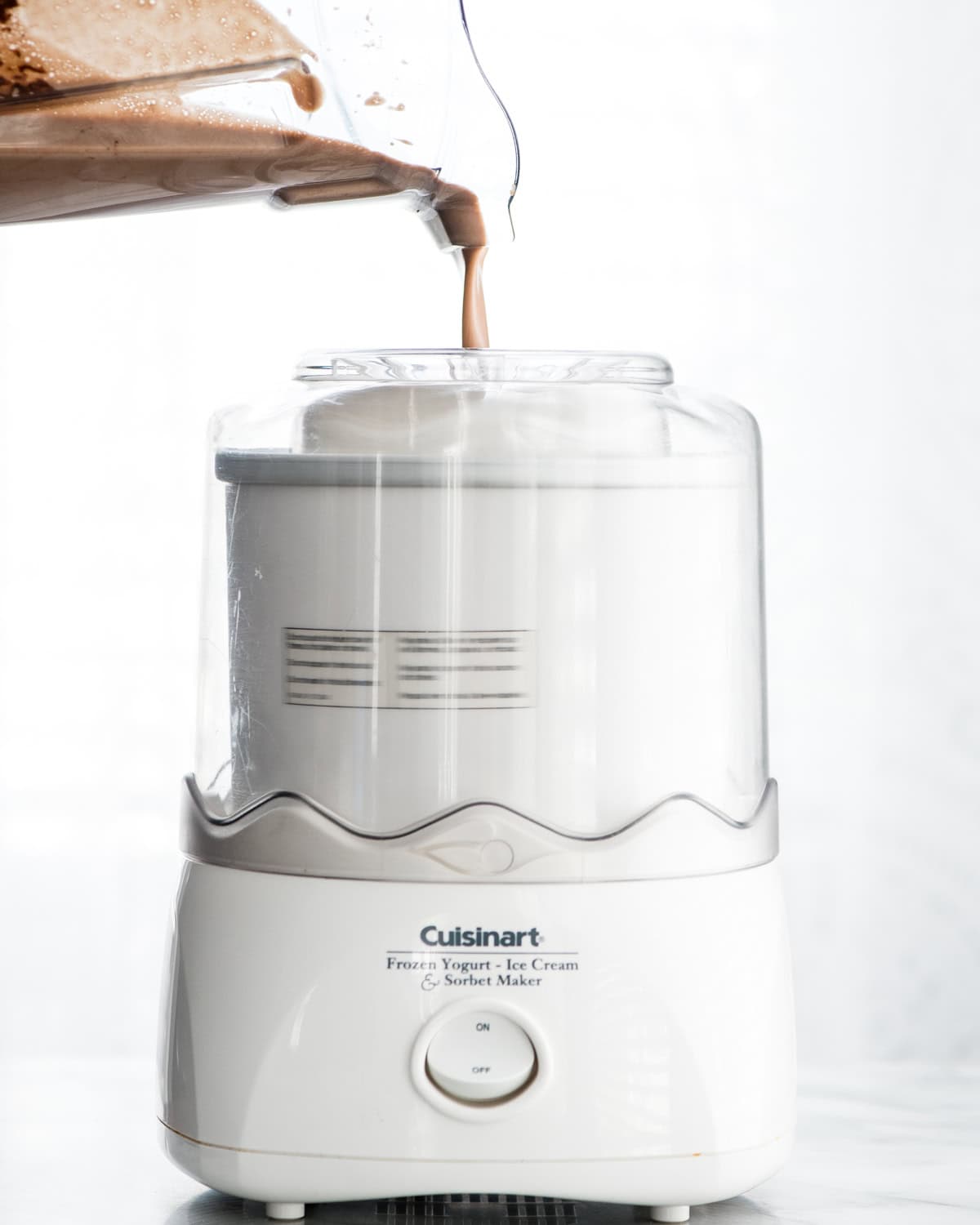 Dairy Free Chocolate Peanut Butter Ice Cream mixture being poured into an ice cream maker