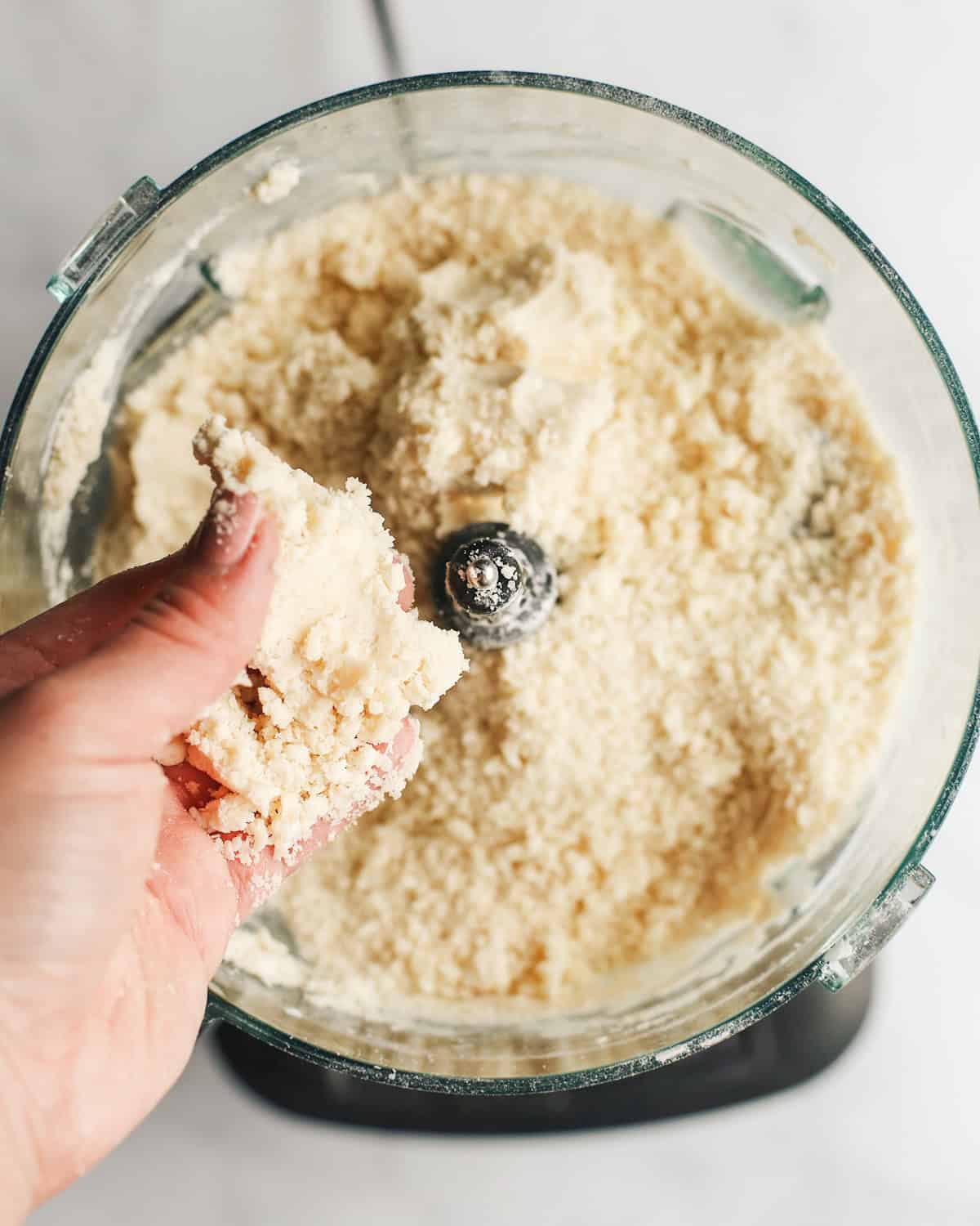 How to Make Peach Pie Crust - dough being pinched together over a food processor