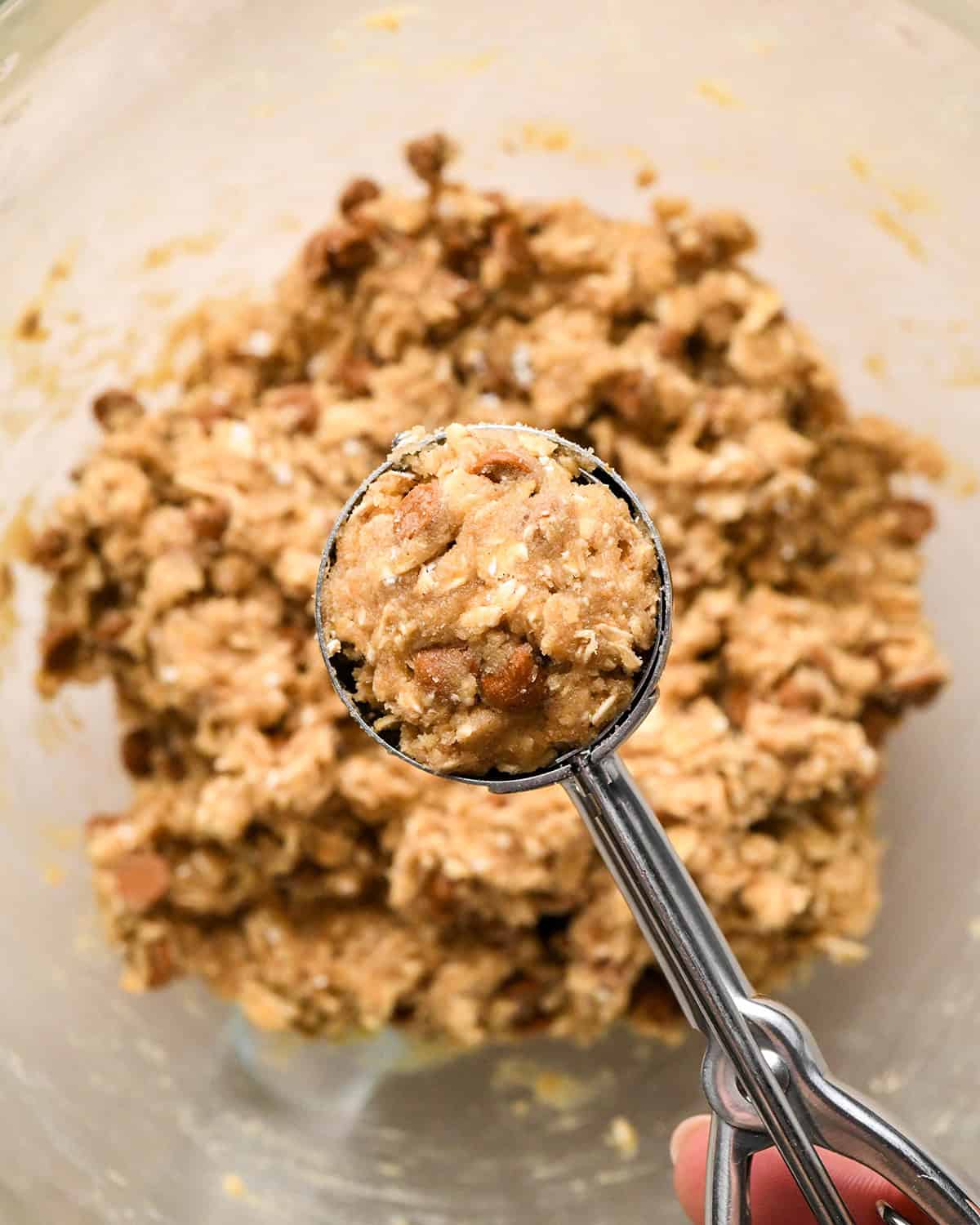 How to Make Iced Oatmeal Cookies - a cookie scoop with dough in it