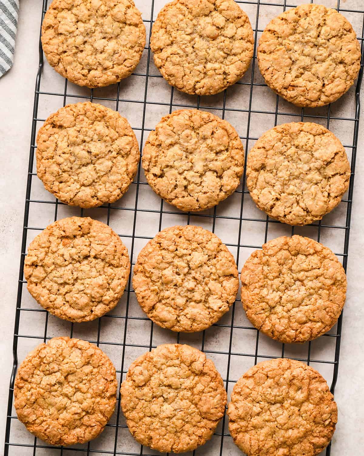 12 Iced Oatmeal Cookies on a wire cooling rack before icing