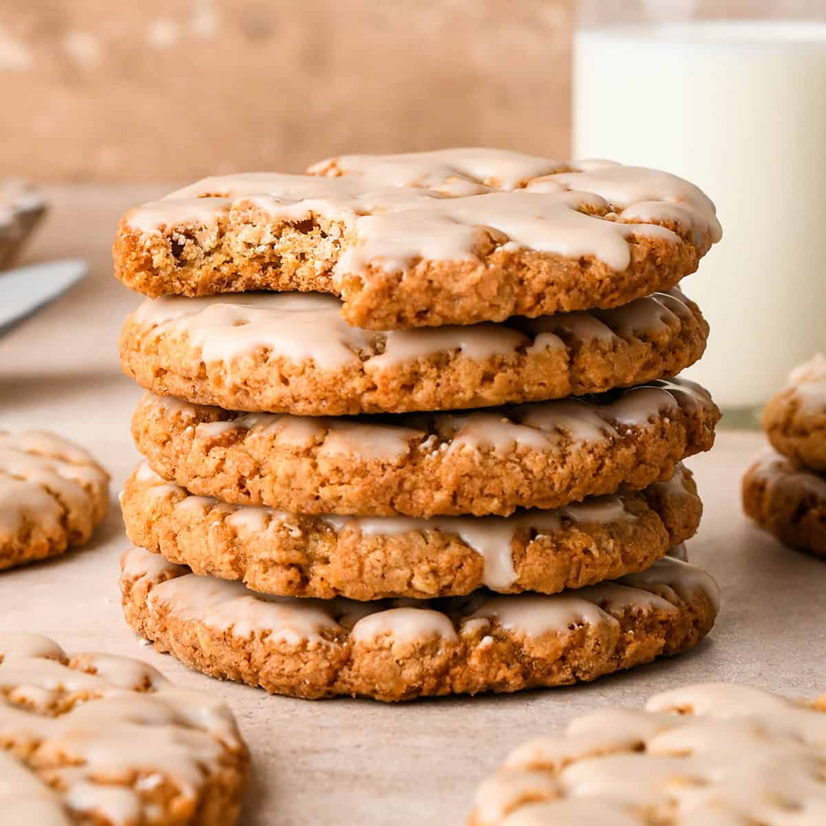 a stack of 5 Iced Oatmeal Cookies, the top one with a bite taken out of it