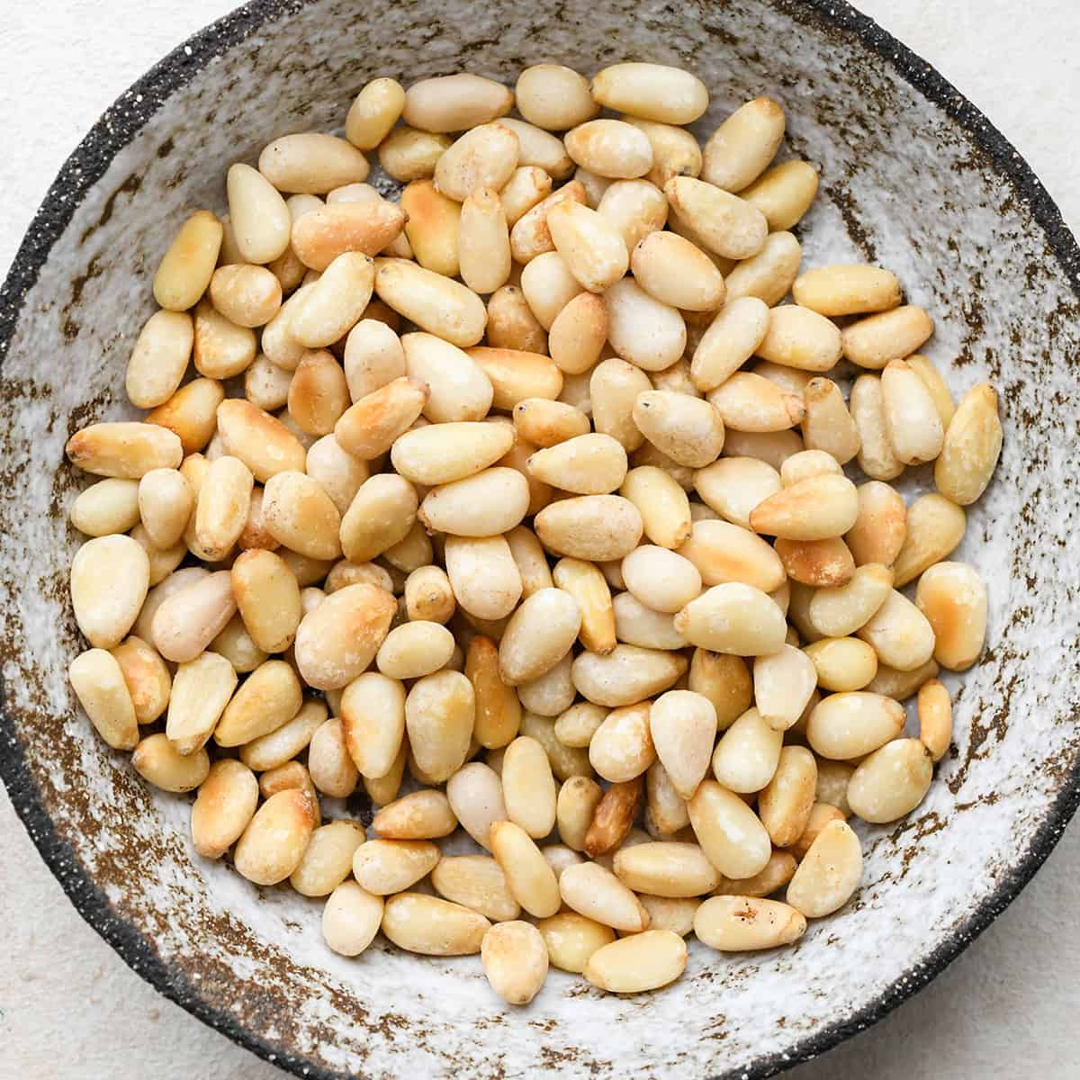 up close photo of pine nuts in a small bowl