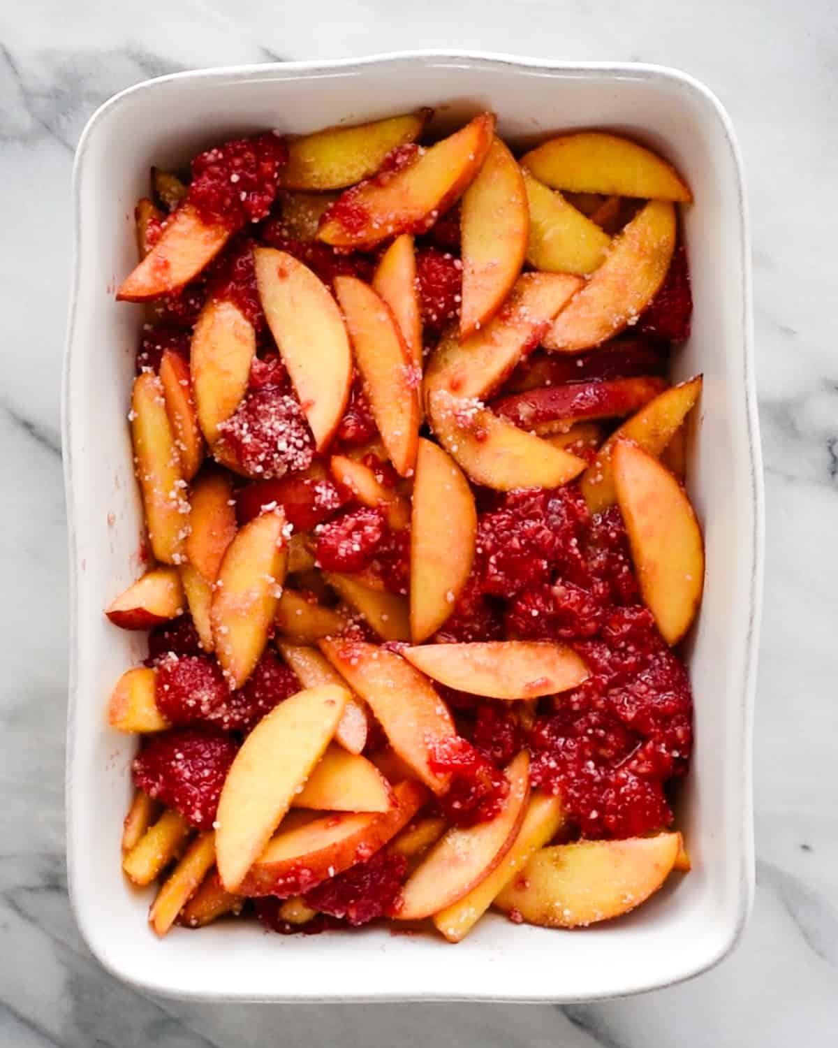 raspberry peach crisp filling spread into a baking dish before making