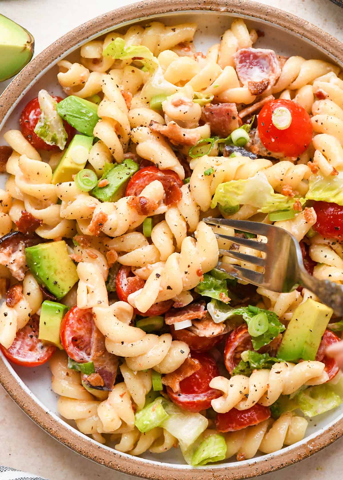 a fork taking a bite of BLT Pasta Salad on a plate