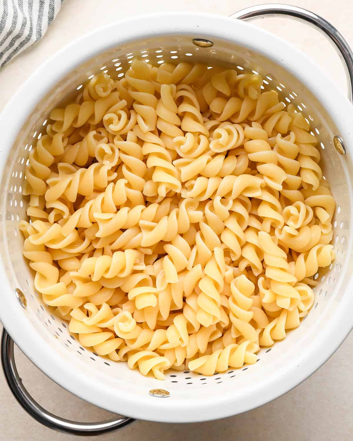 cooked rotini noodles in a colander