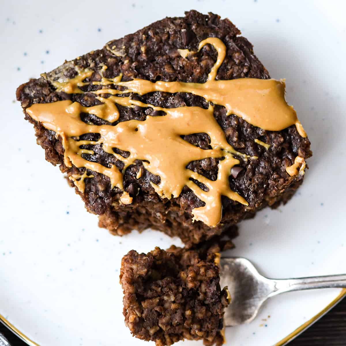 a piece of Baked Chocolate Peanut Butter Oatmeal on a plate with a fork taking a bite