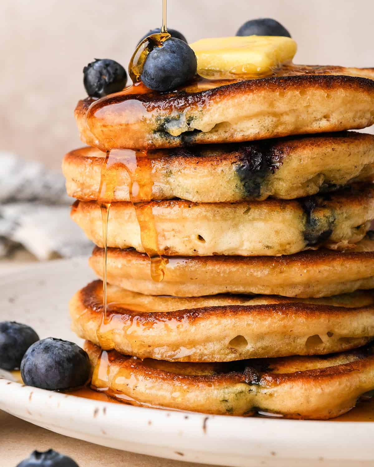 a stack of 6 Blueberry Pancakes with butter and syrup