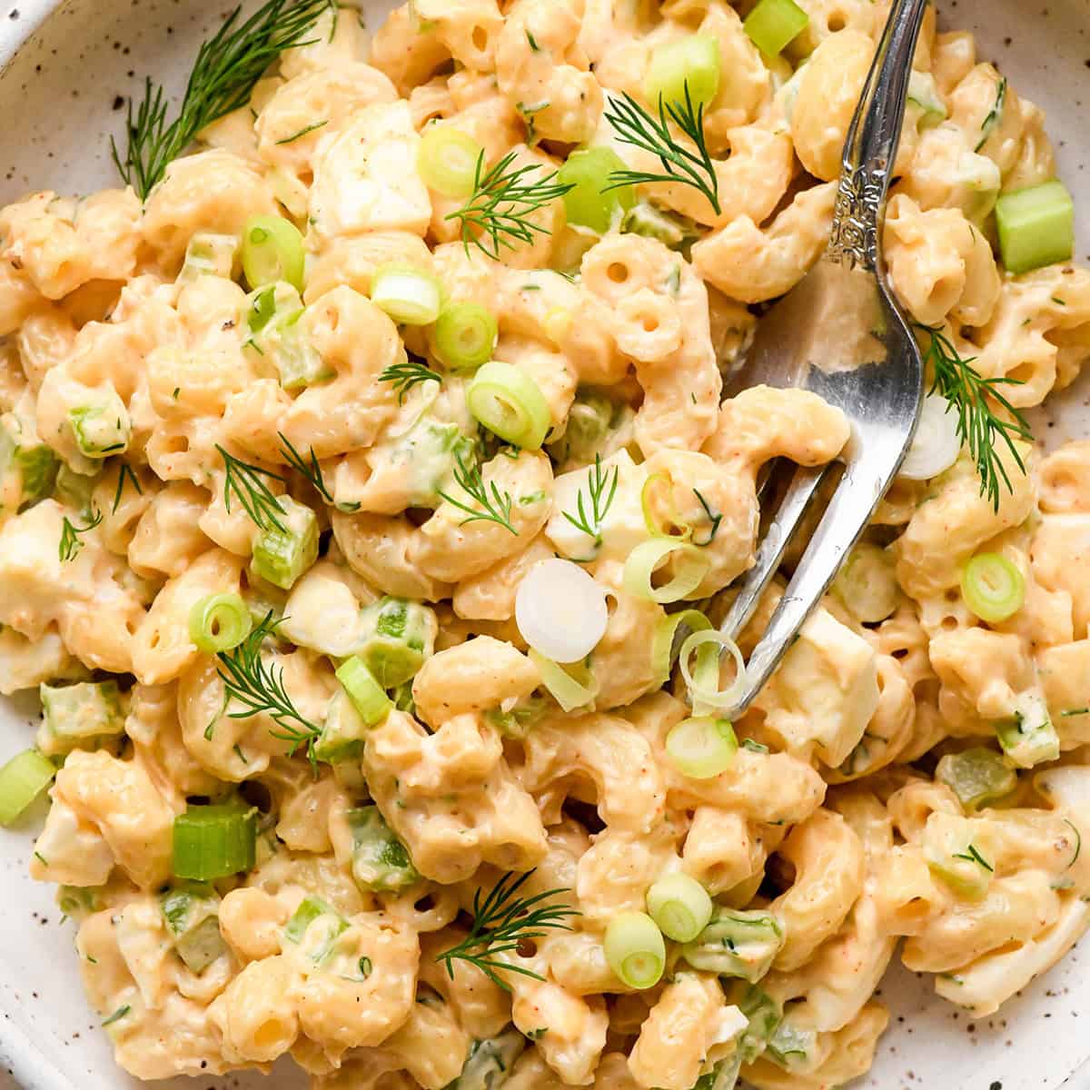 a fork taking a bite of Macaroni Salad on a plate