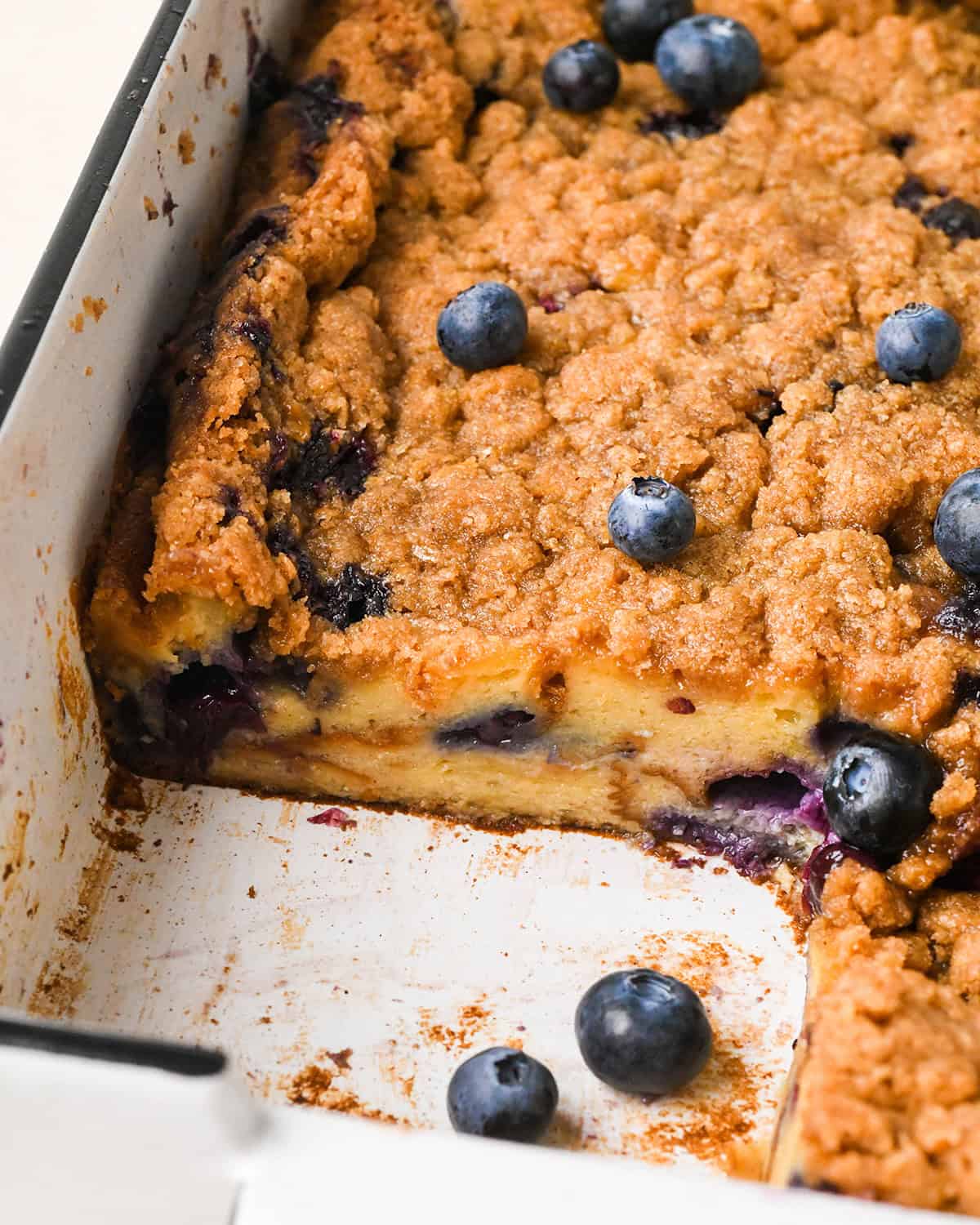 Blueberry French Toast Casserole  in a baking dish with a piece cut out of it