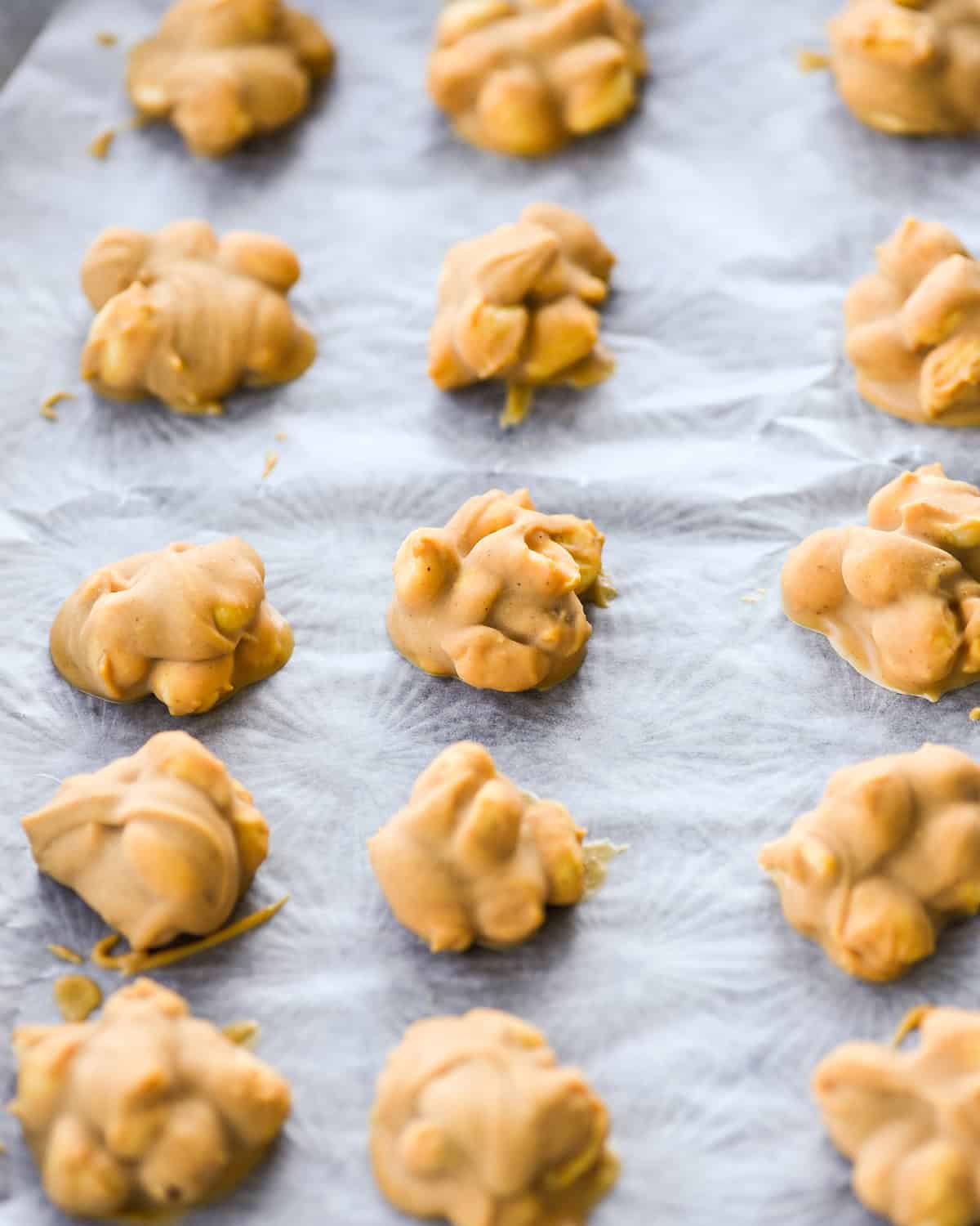 How to Make Chocolate Peanut Clusters - clusters frozen on a baking sheet