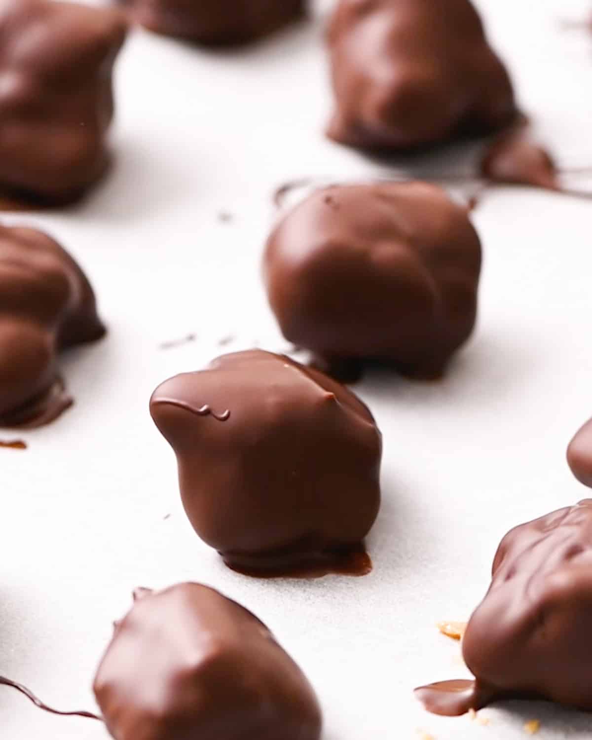 dipped peanut clusters on a baking sheet 