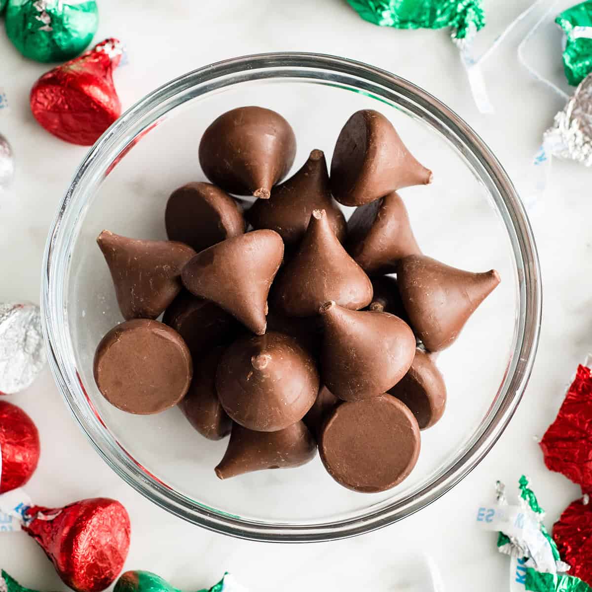 a bowl of unwrapped hershey kisses to make Gluten Free Peanut Butter Blossoms