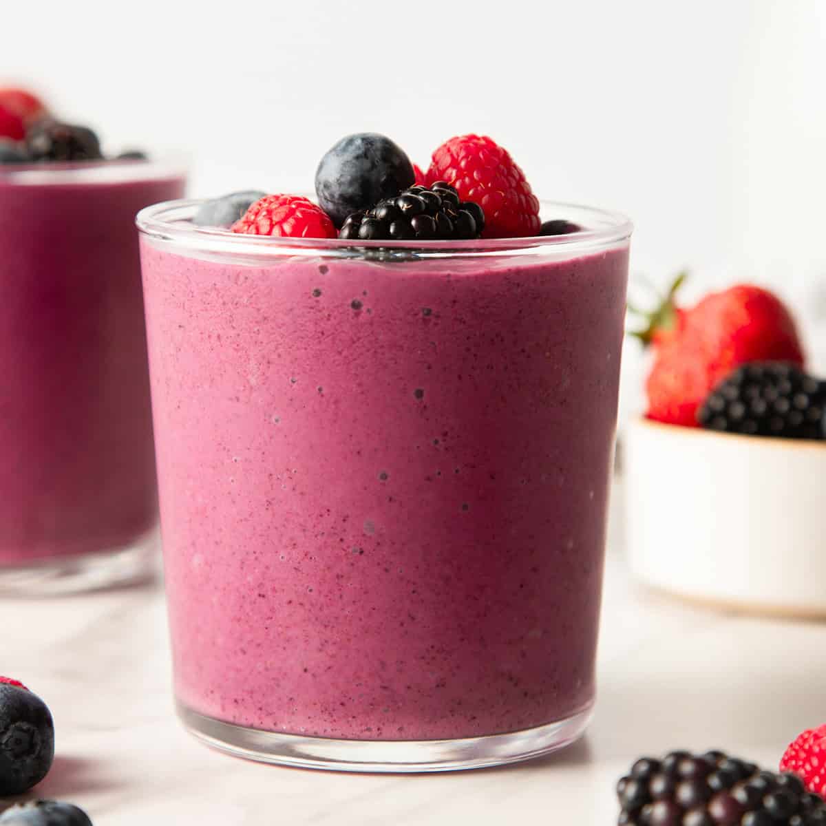 greek yogurt smoothie in a glass cup topped with berries