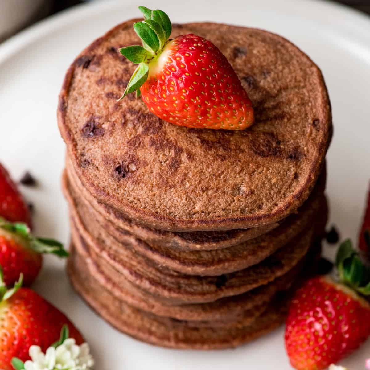a stack of Healthy Chocolate Pancakes with a strawberry on top