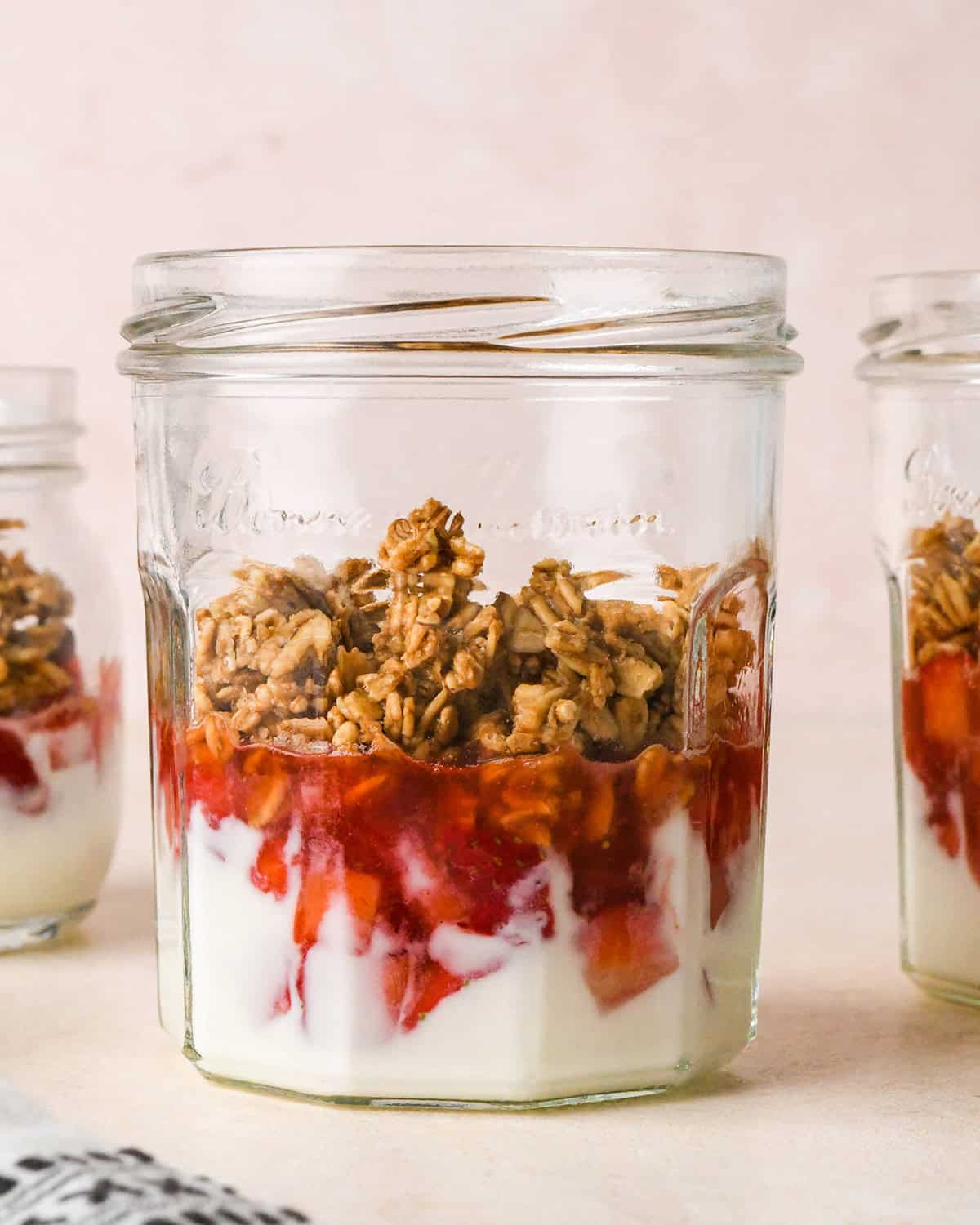 How to Make a Yogurt Parfait - granola on top of the strawberry layer in a jar