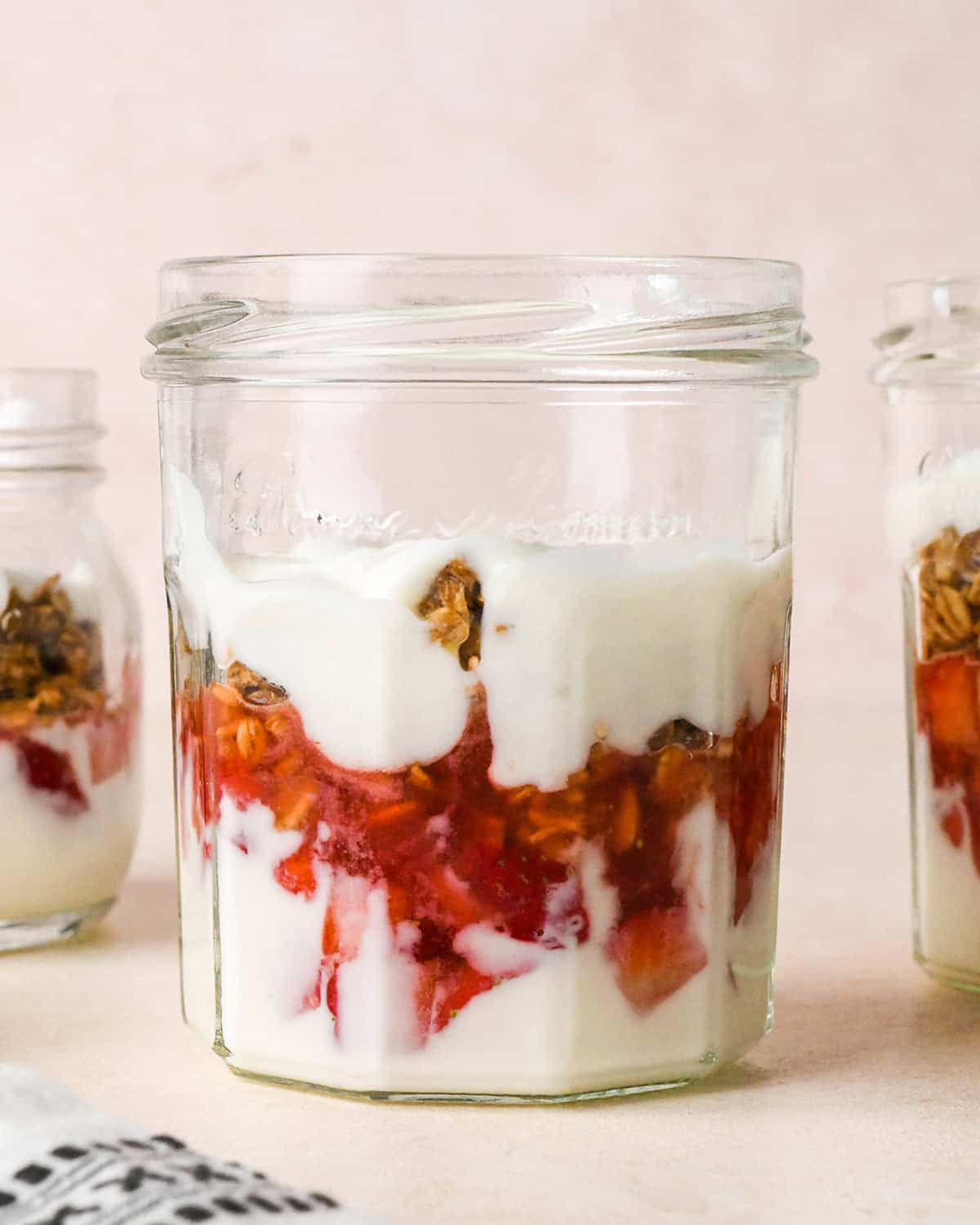 How to Make a Yogurt Parfait - second layer of yogurt on top of the granola layer in a glass jar