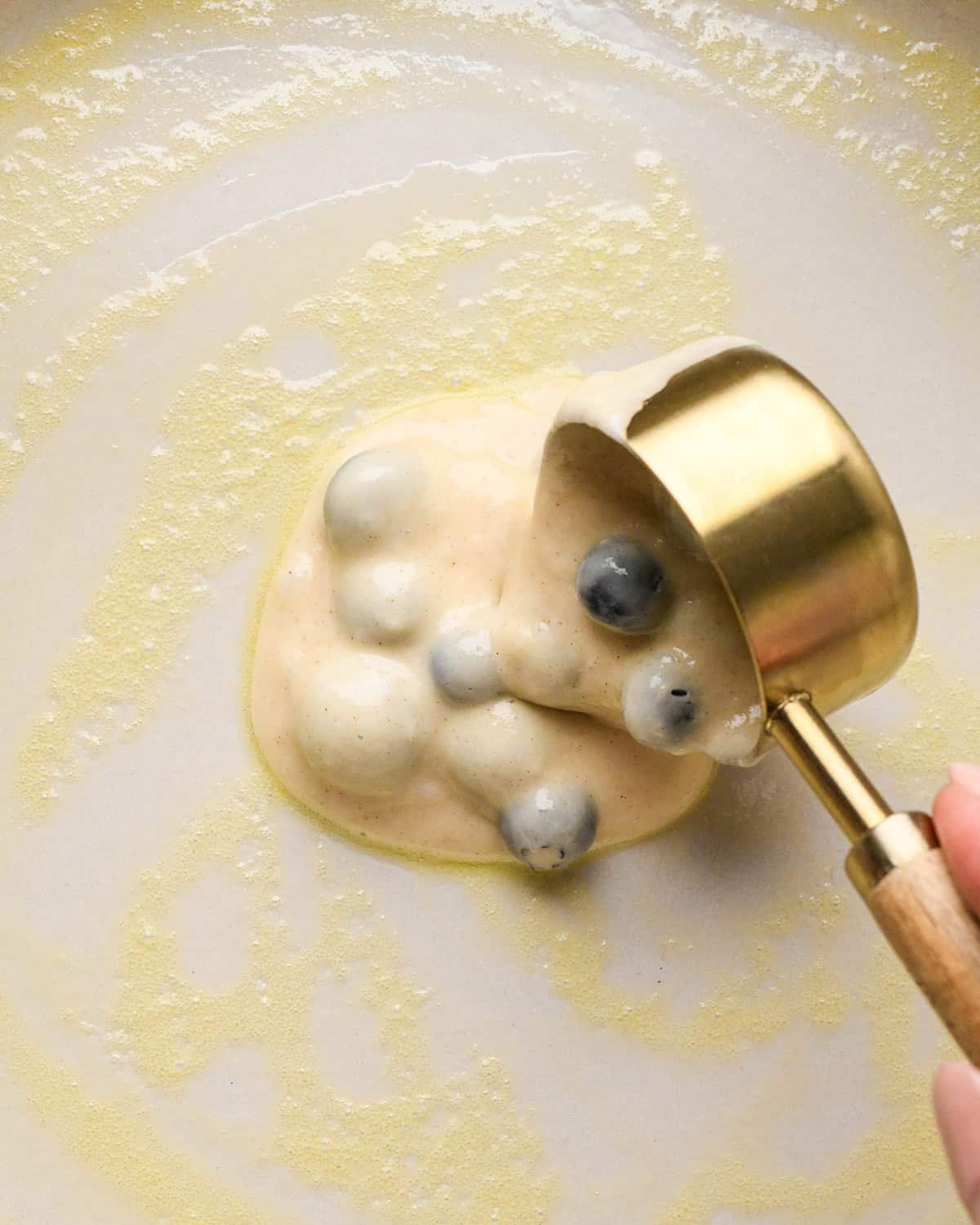 How to Make Blueberry Pancakes - pouring batter onto pan