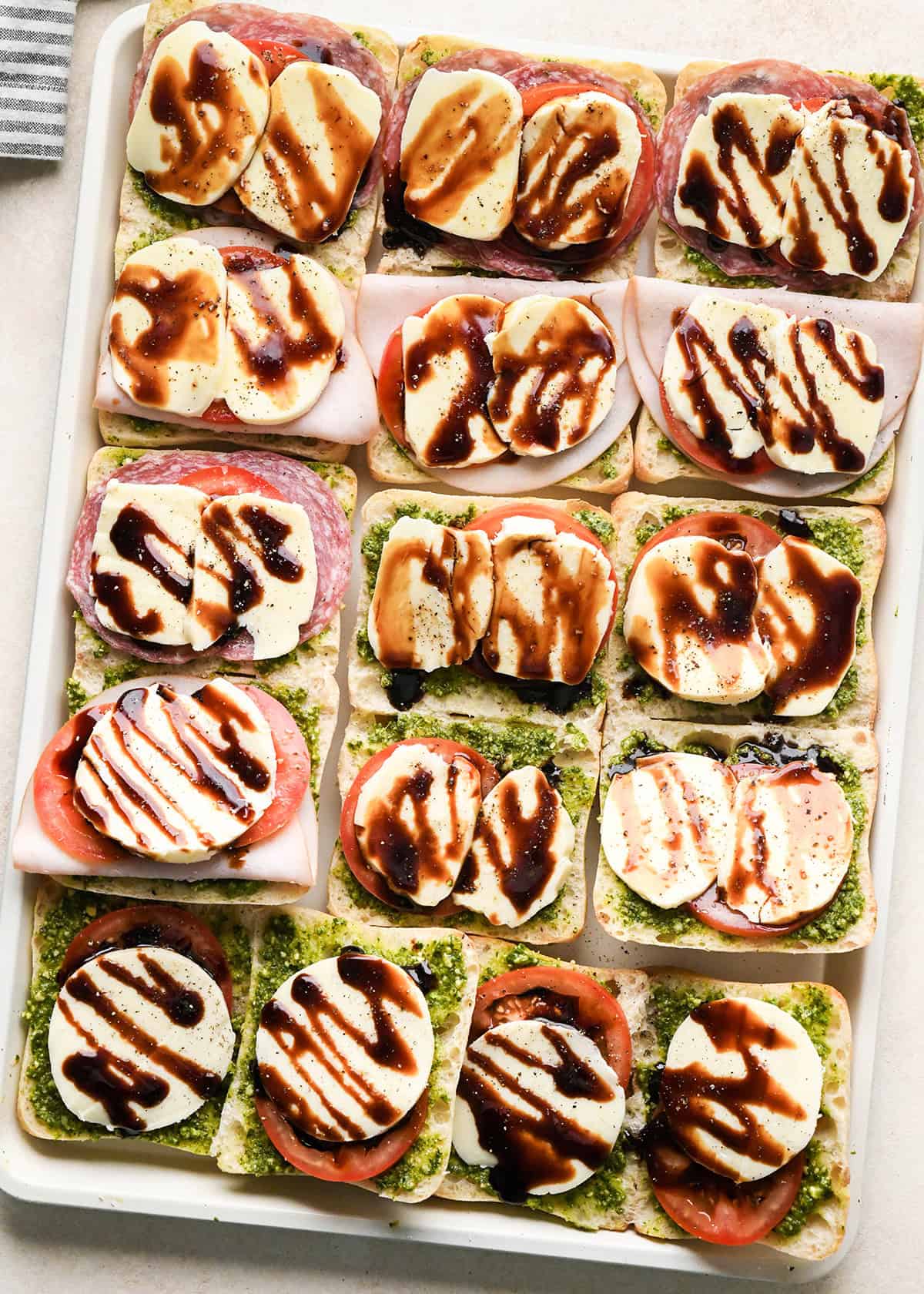 8 Caprese Sandwiches on a baking sheet before baking