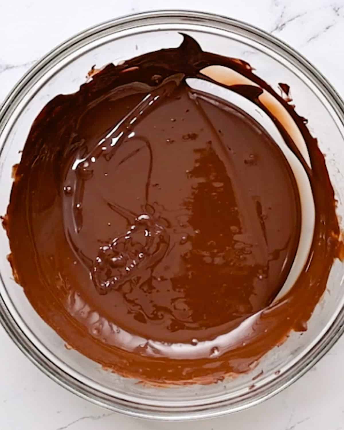 How to Make Chocolate Covered Cashews - tempered and melted chocolate in a bowl. 