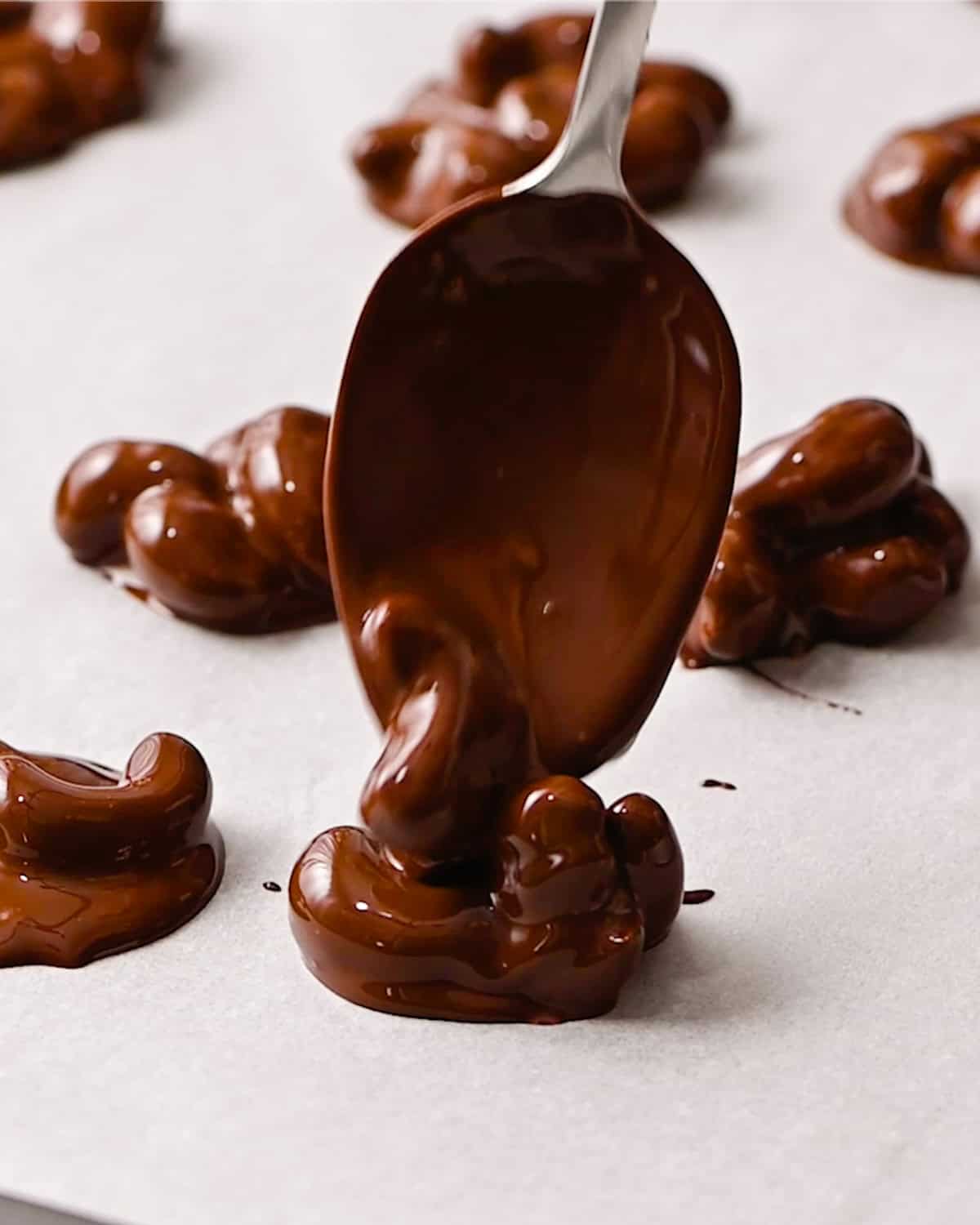 How to Make Chocolate Covered Cashews - making clusters on a parchment-lined baking sheet