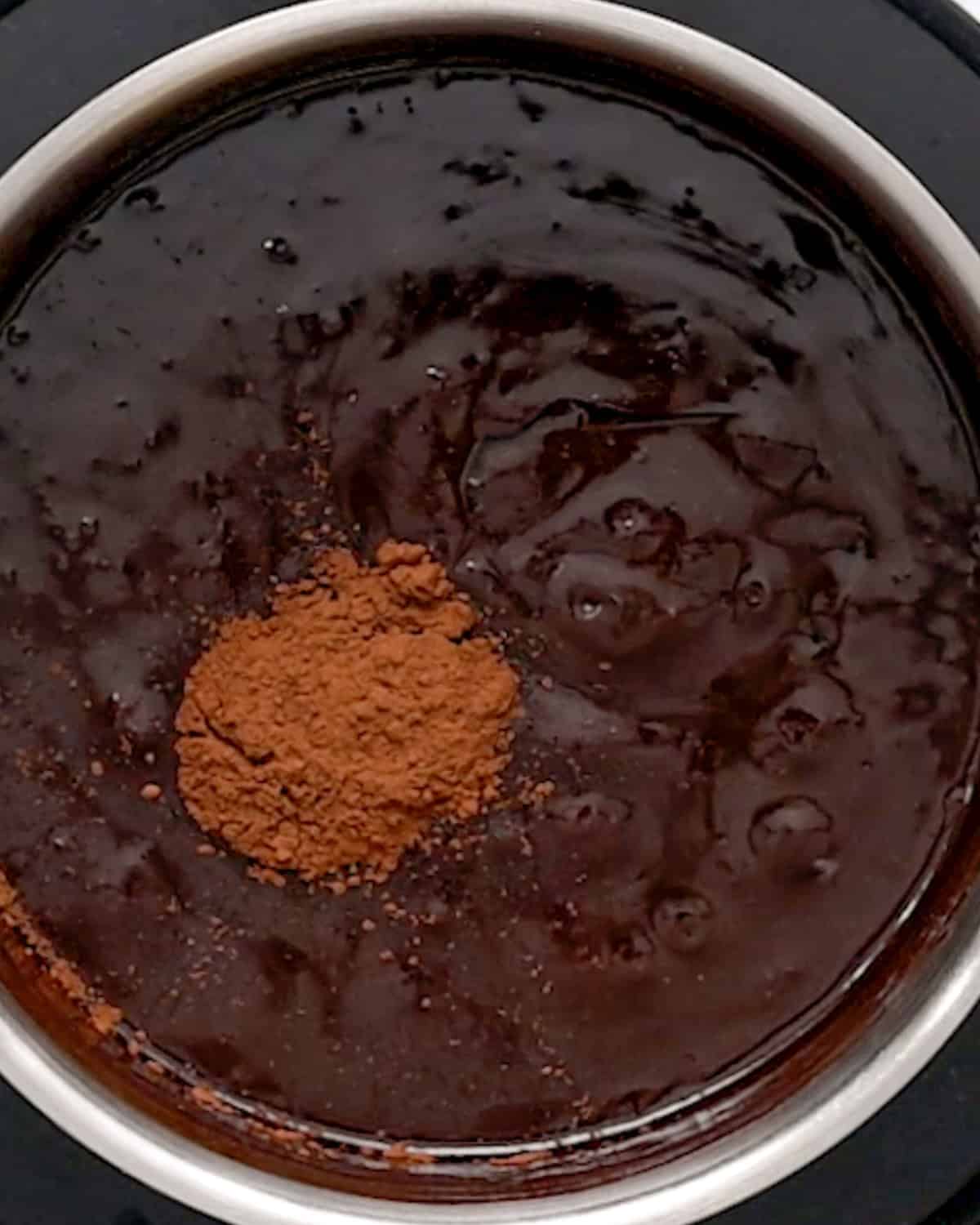 making  Chocolate Peanut Butter Fondue  in a pot- adding cocoa powder and vanilla