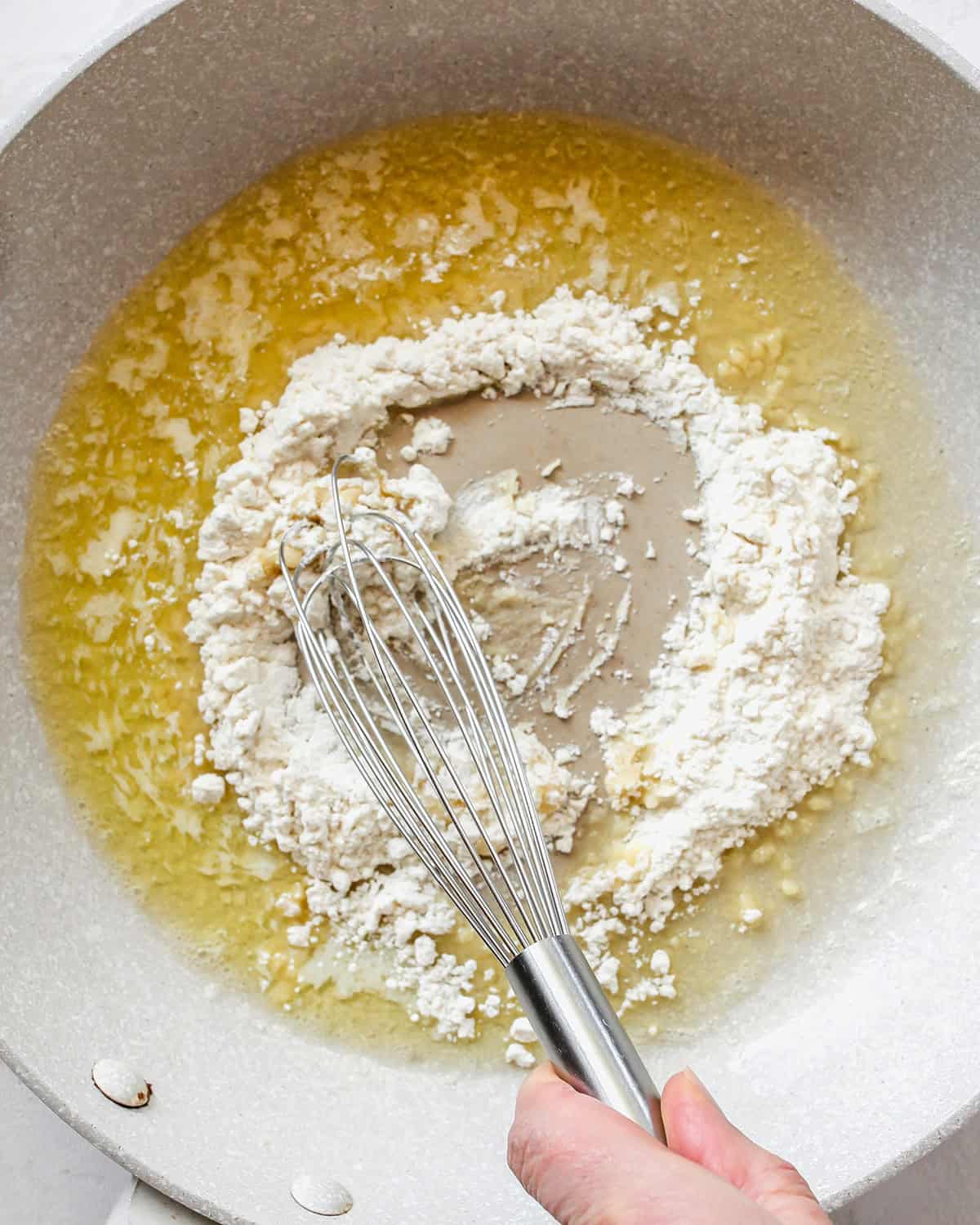 making cheese sauce for Greek Yogurt Mac & Cheese - whisking dry ingredients into butter