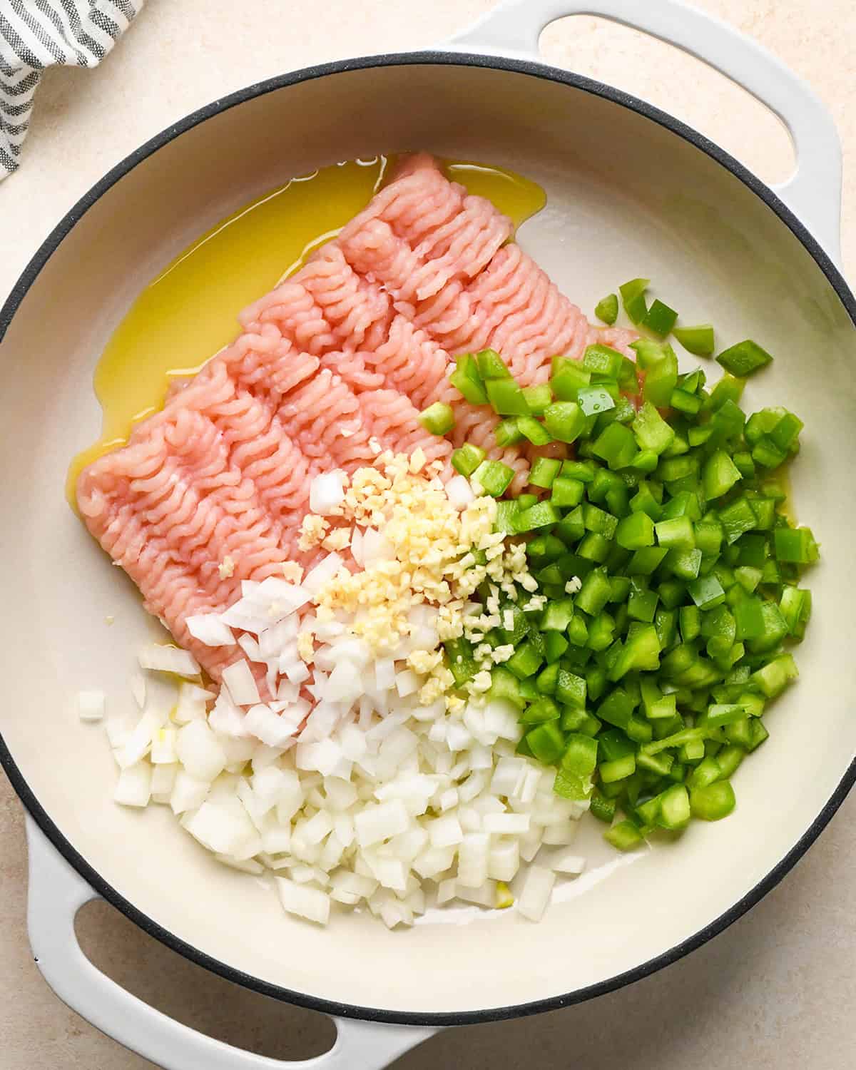 How to Make Ground Turkey Tacos - turkey, green pepper, onion, garlic and olive oil in a pan before cooking