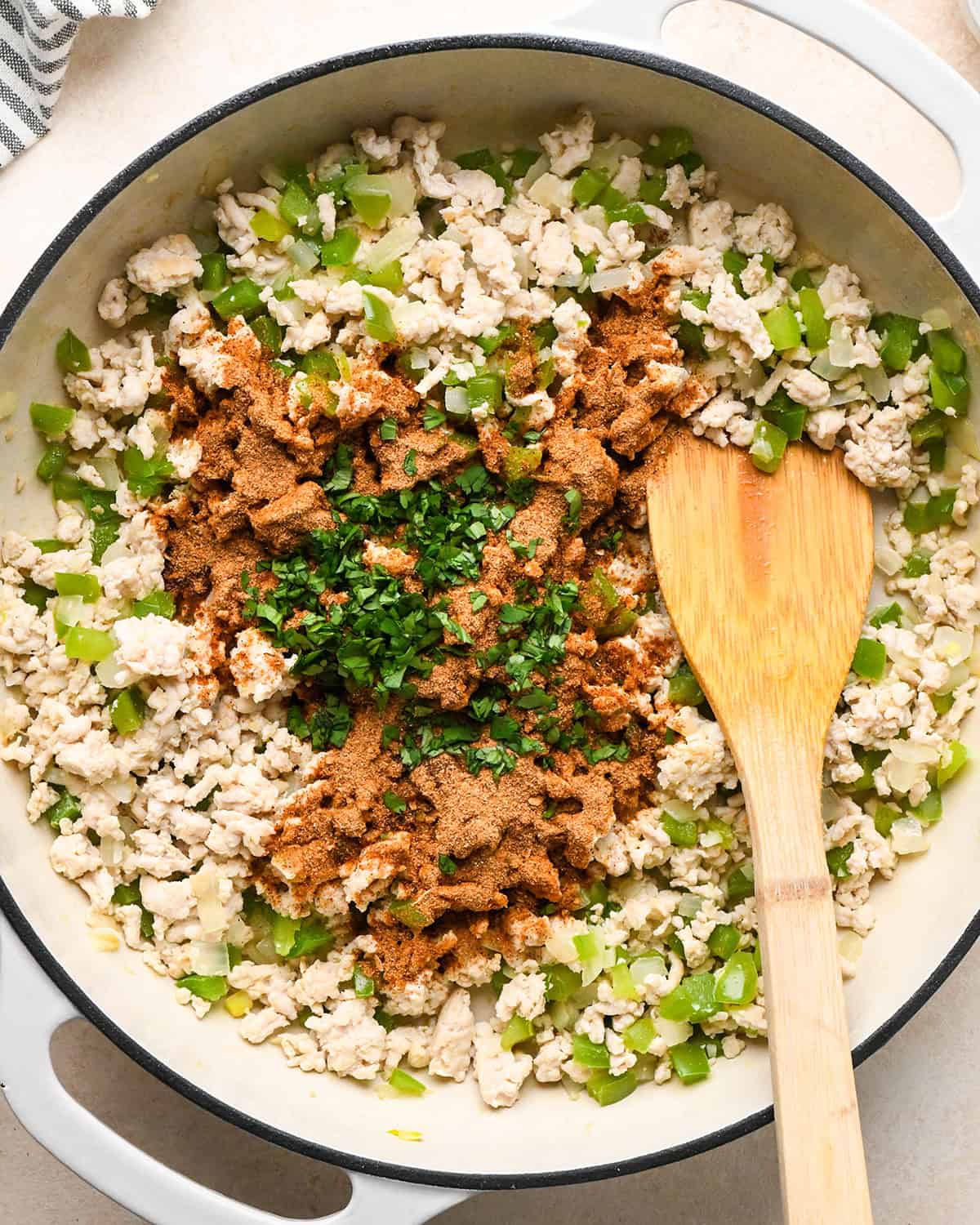 How to Make Ground Turkey Tacos - adding cilantro and taco seasoning to cooked turkey