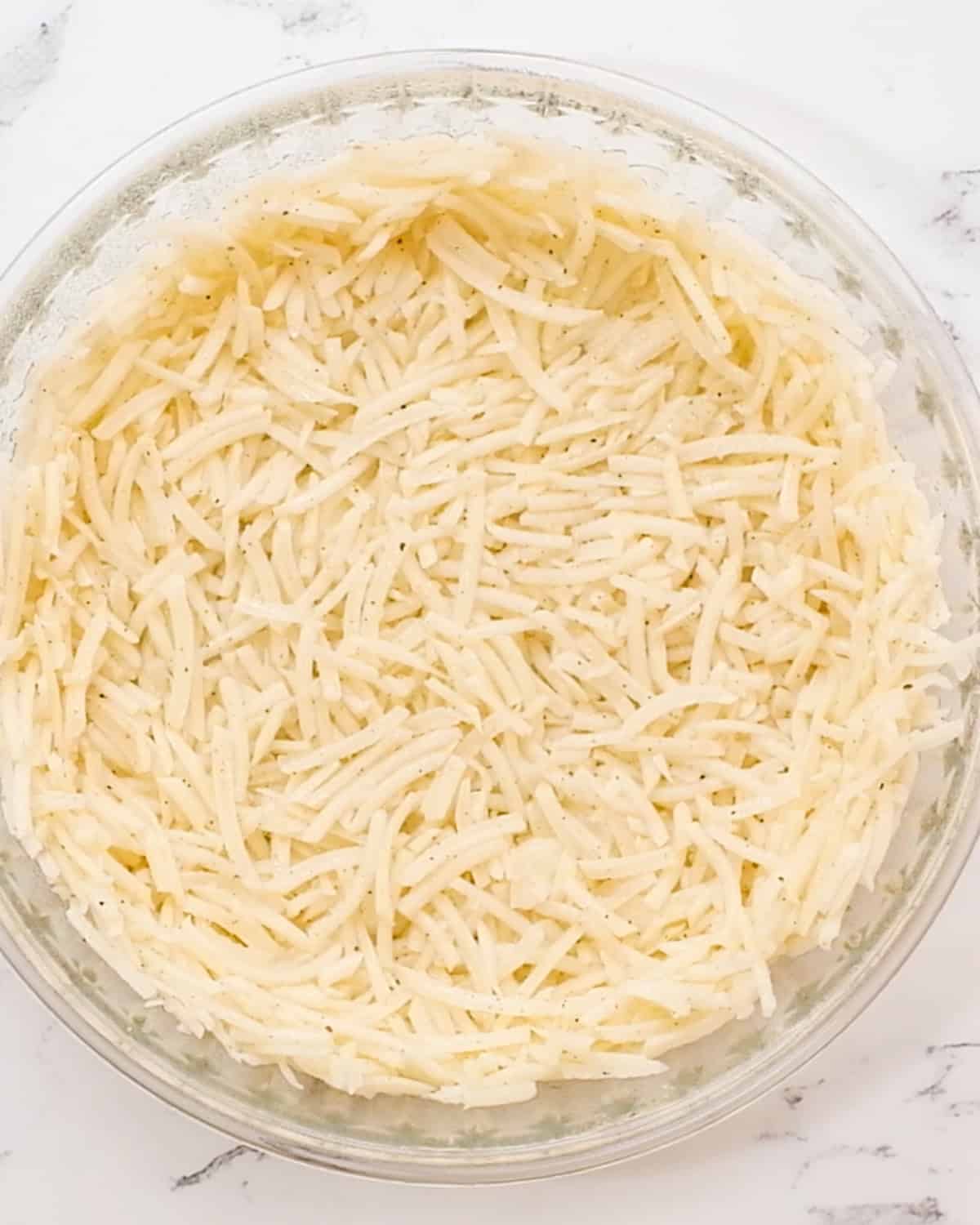 hash brown crust in a pie dish before baking