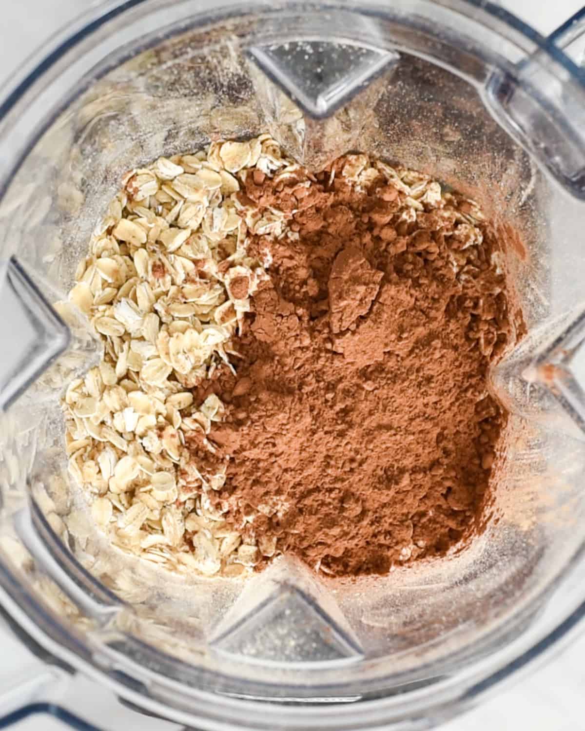 oats and cocoa powder in the container of a blender before blending to make Healthy Chocolate Pancakes 