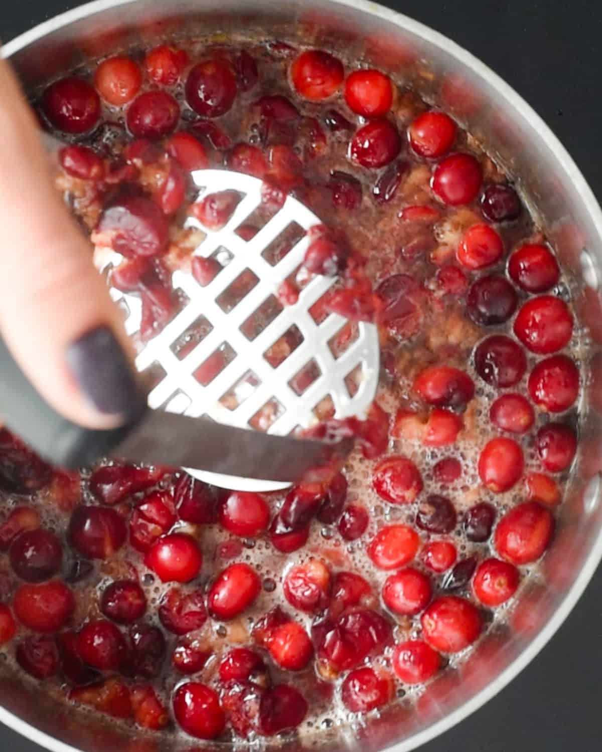 How to Make Healthy Cranberry Sauce mashing cranberries