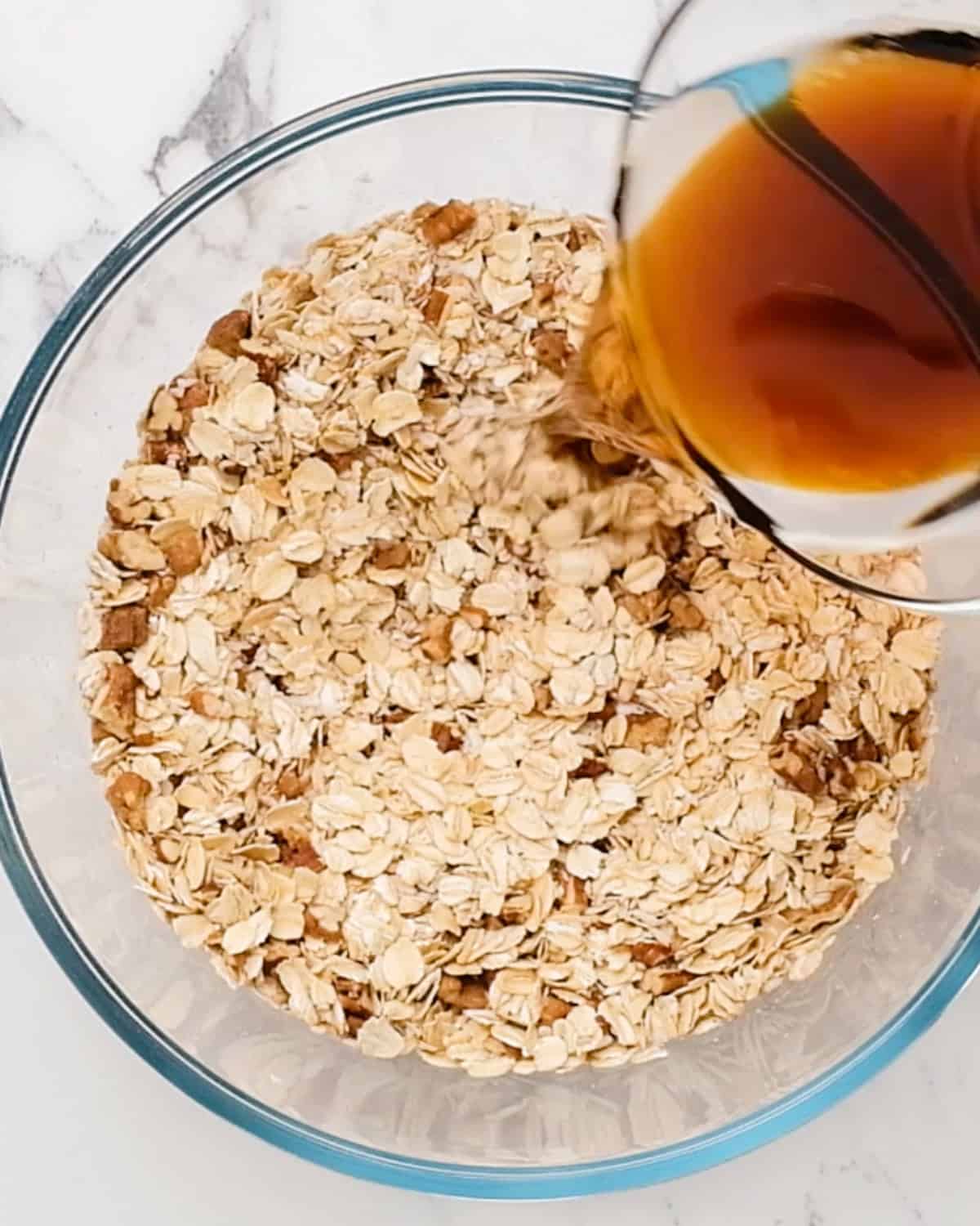 How to Make Homemade Granola - pouring wet ingredients into dry ingredients in a bowl