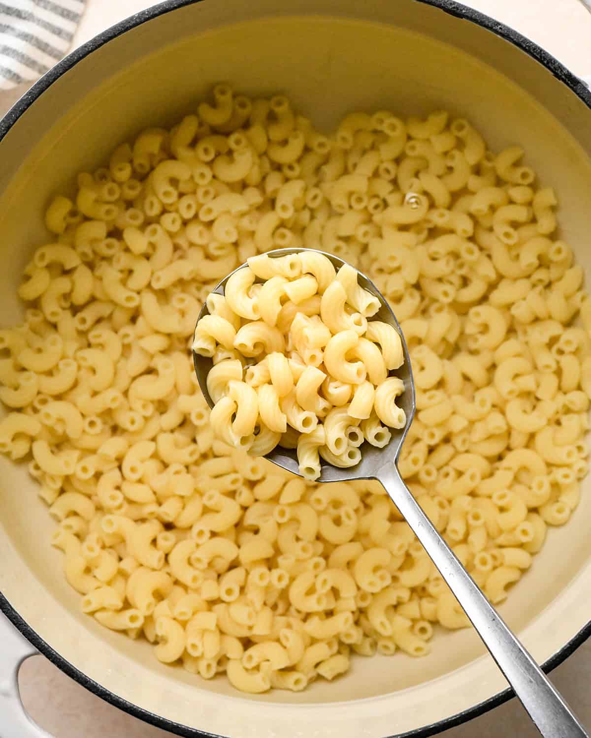cooked macaroni in a pot with a spoon