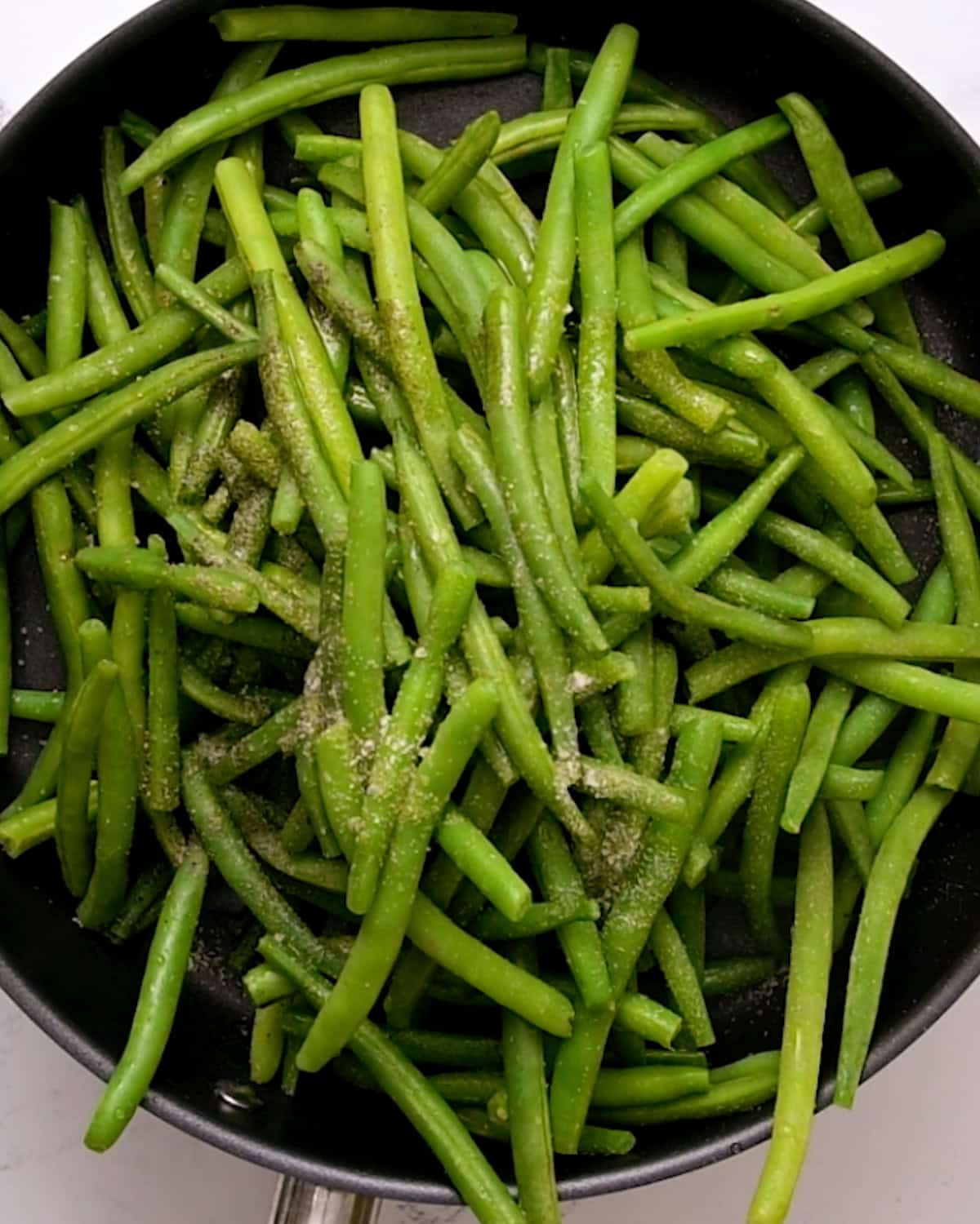 How to Make Sautéed Green Beans adding garlic powder, salt and pepper
