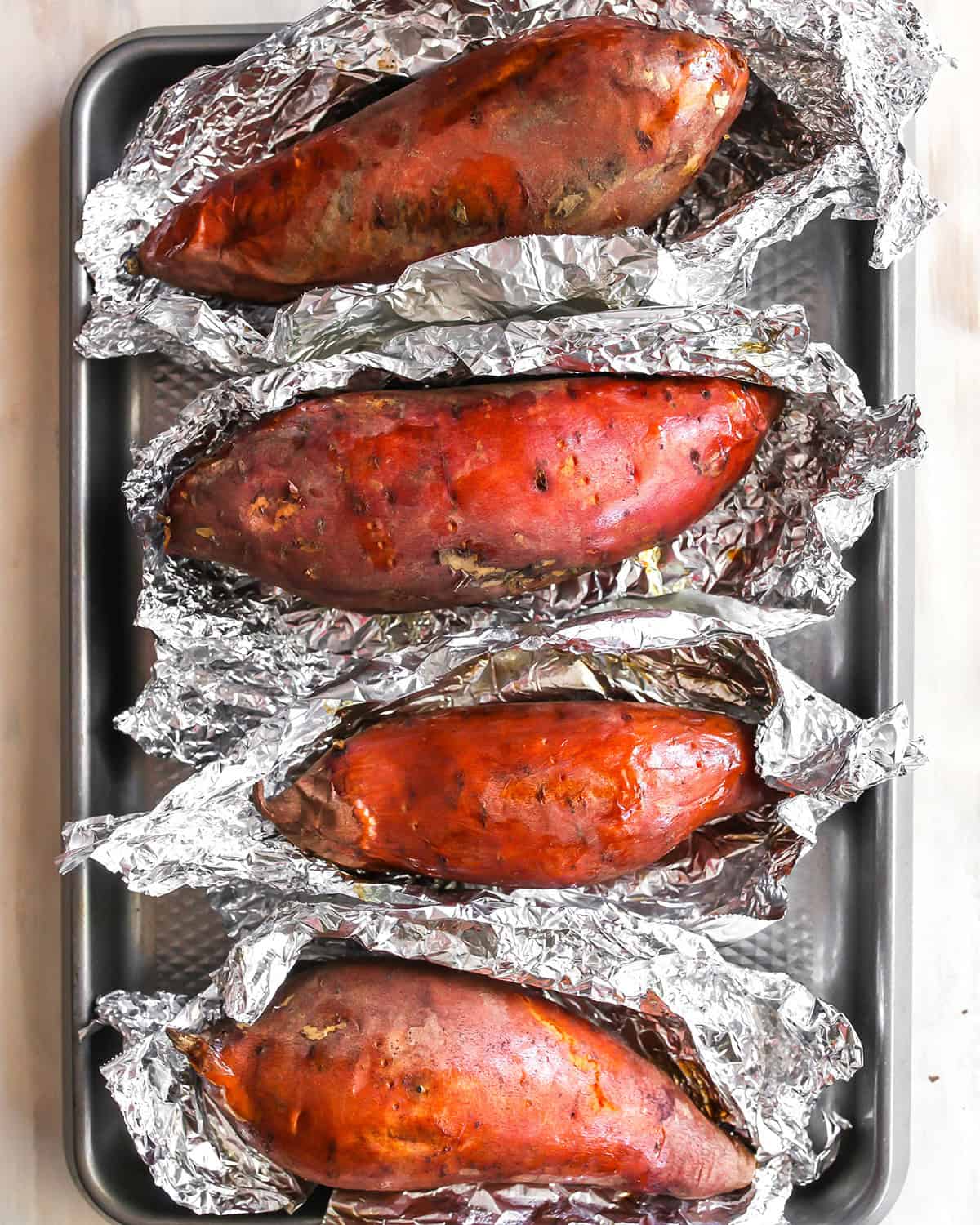 How to Make Sweet Potato Baby Food - sweet potatoes on a baking sheet after opening foil