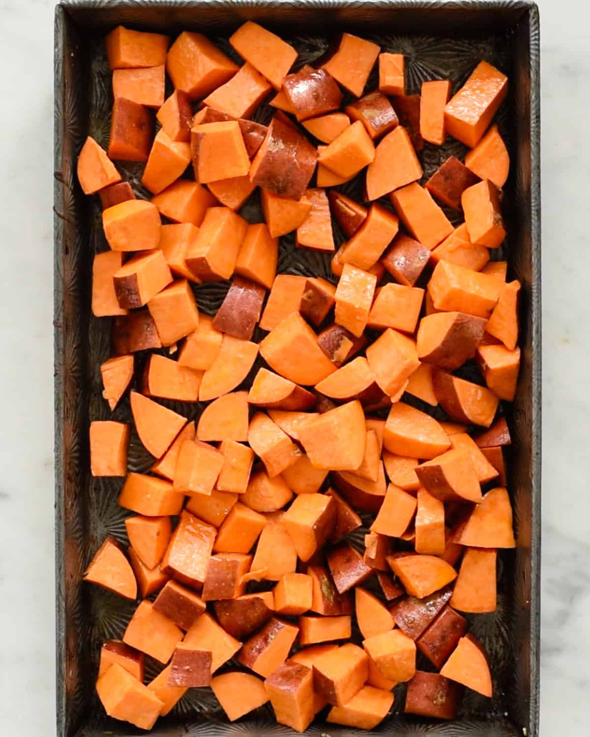 how to make Cinnamon Roasted Sweet Potatoes - sweet potatoes on a baking sheet before roasting