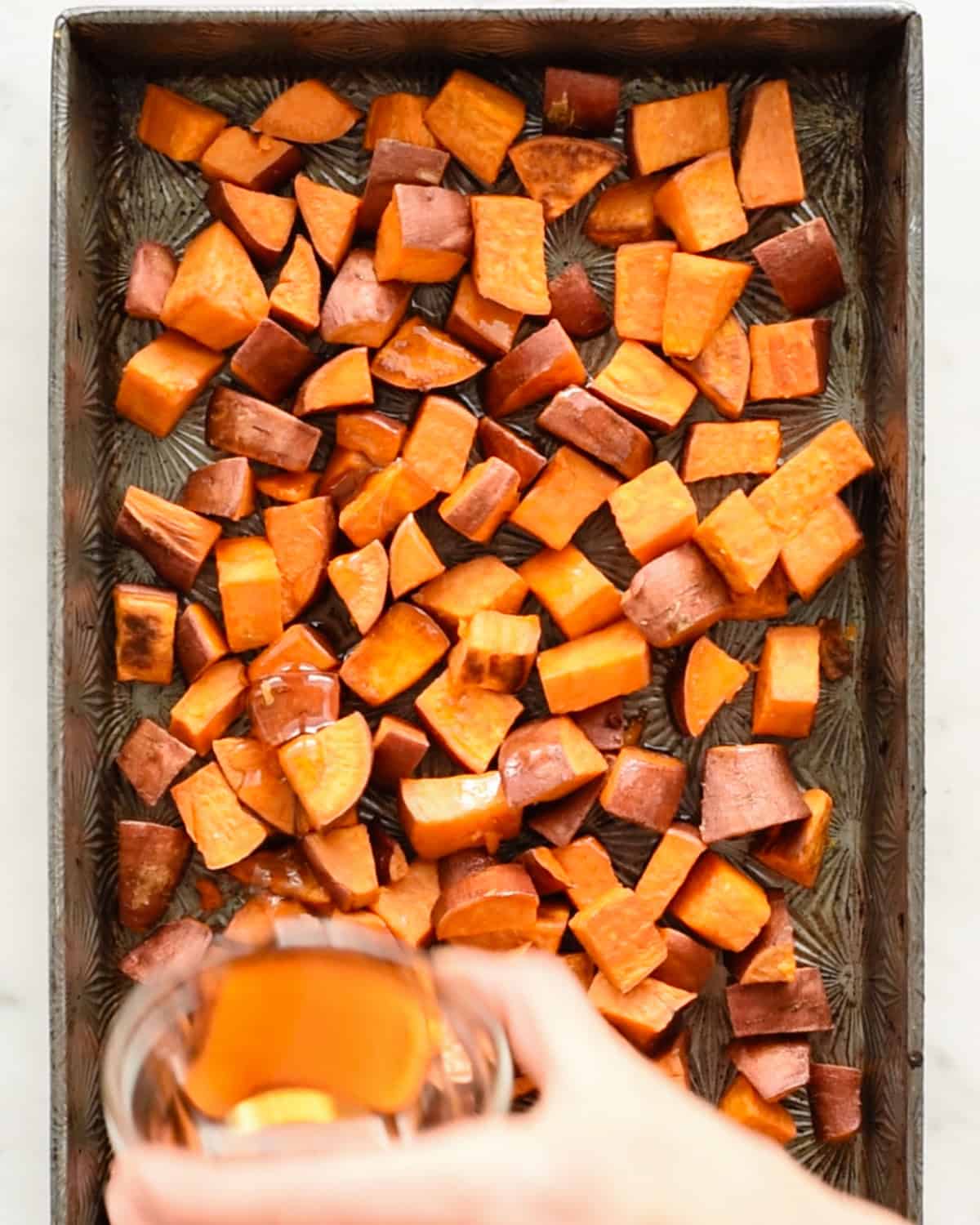 how to make Cinnamon Roasted Sweet Potatoes - adding maple syrup to partially roasted sweet potatoes