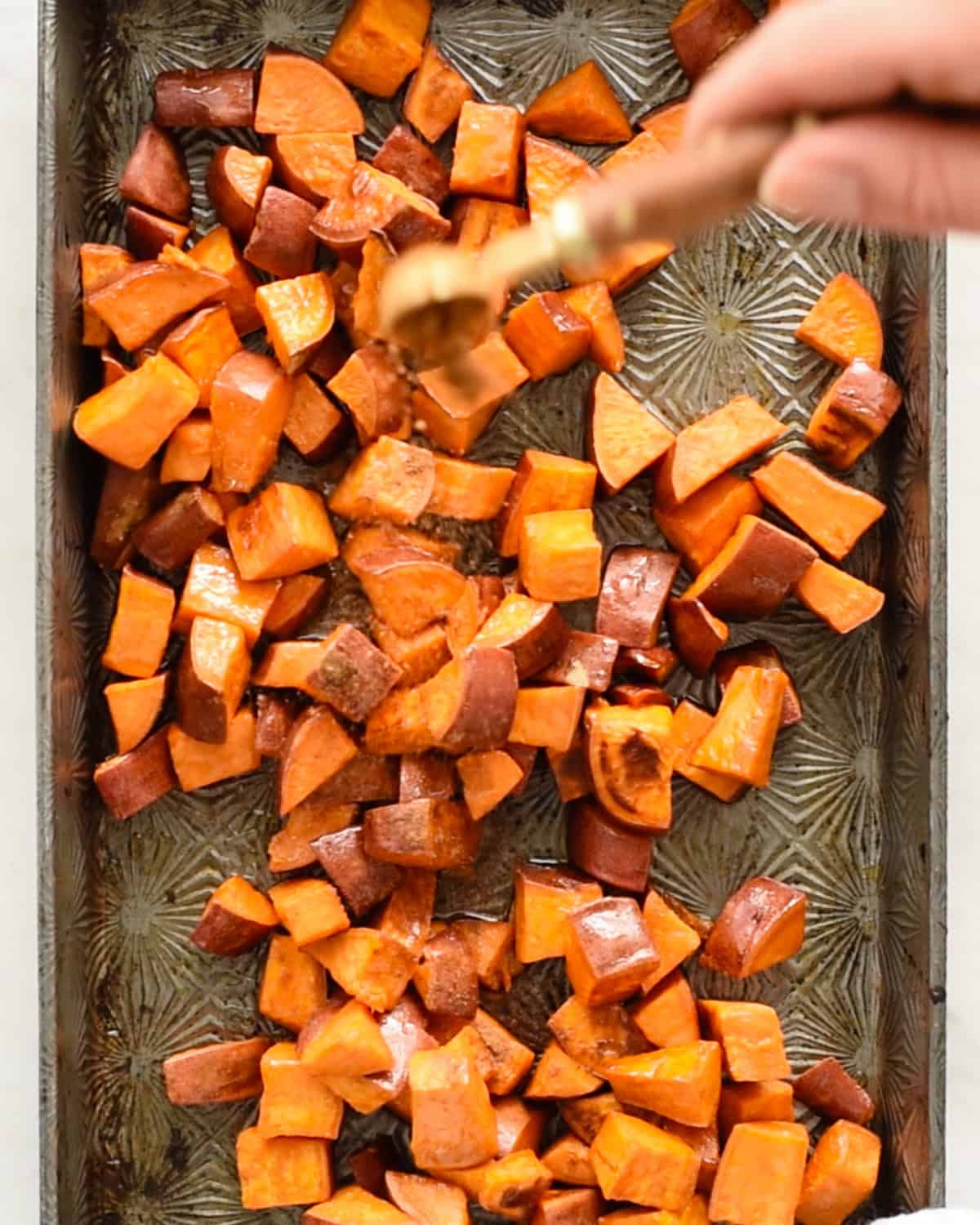 how to make Cinnamon Roasted Sweet Potatoes - adding cinnamon to to partially roasted sweet potatoes