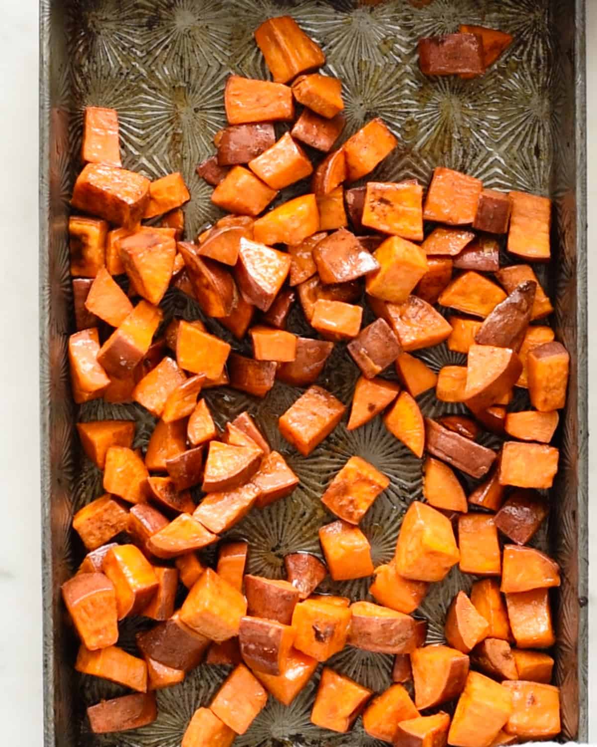 how to make Cinnamon Roasted Sweet Potatoes - on a baking sheet after stirring in ingredients
