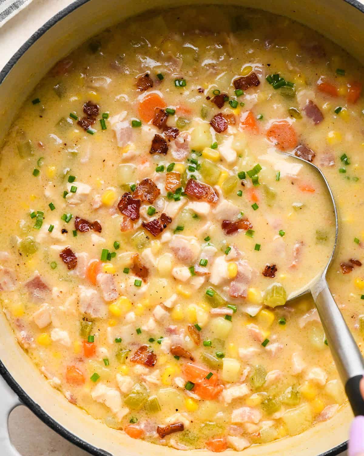 a ladle taking a scoop of Sweet Corn & Chicken Soup out of a pot