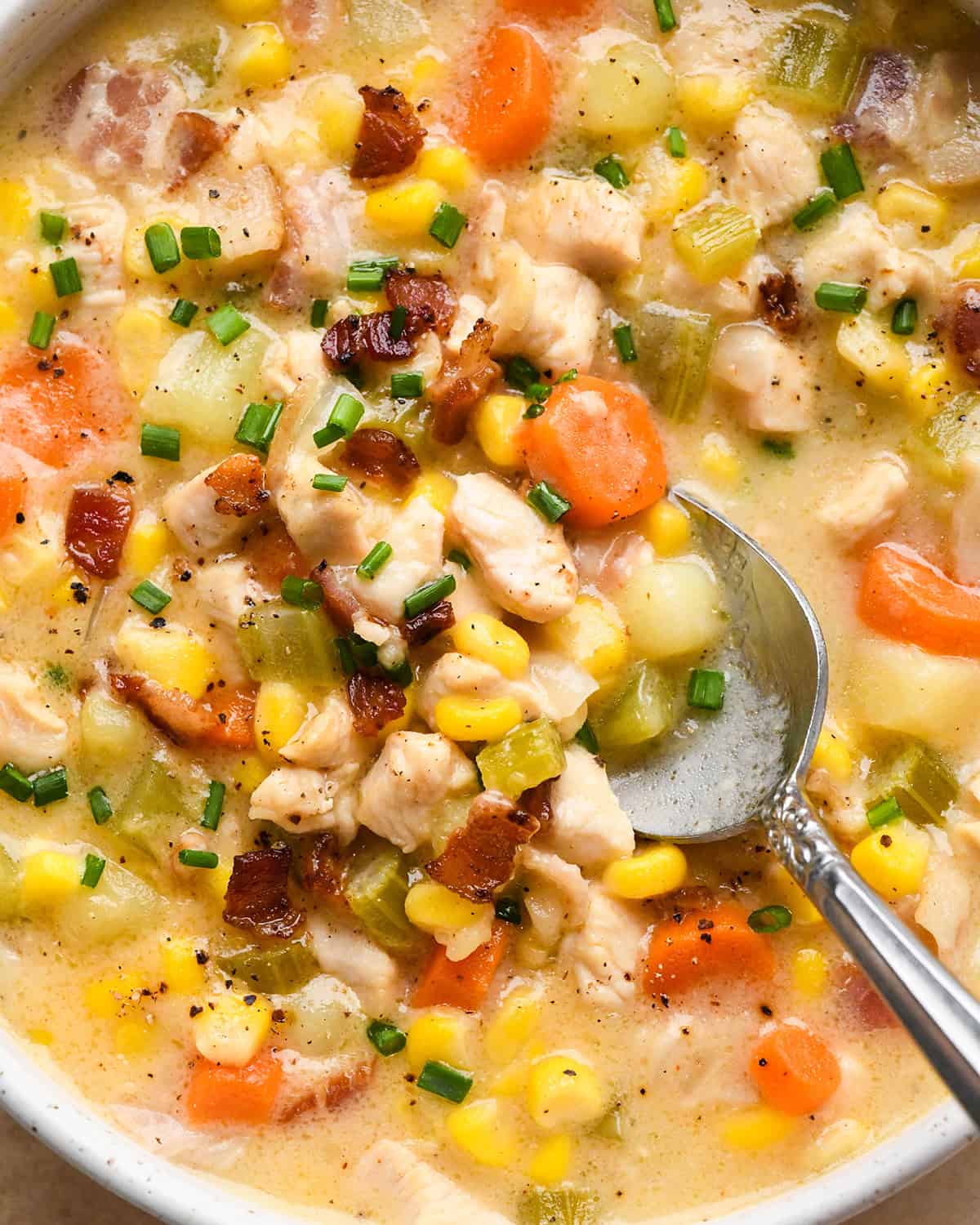 a spoon taking a bite of Sweet Corn & Chicken Soup