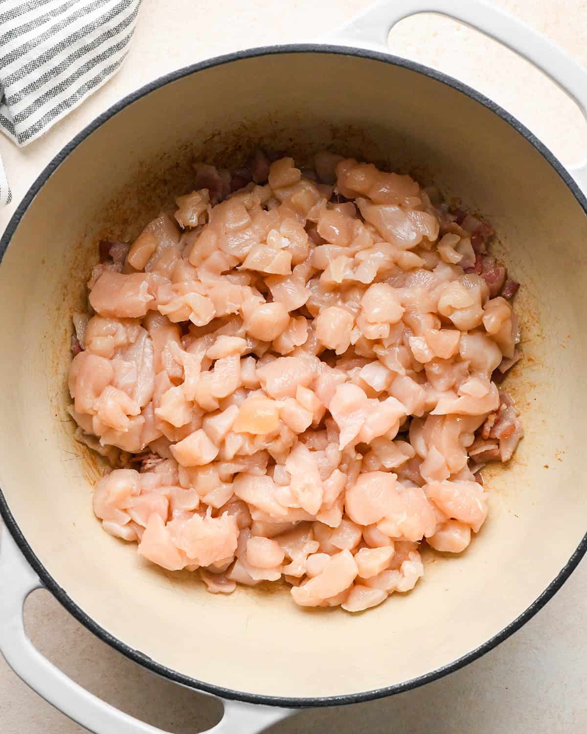 making Sweet Corn & Chicken Soup - adding raw chicken to partially cooked bacon